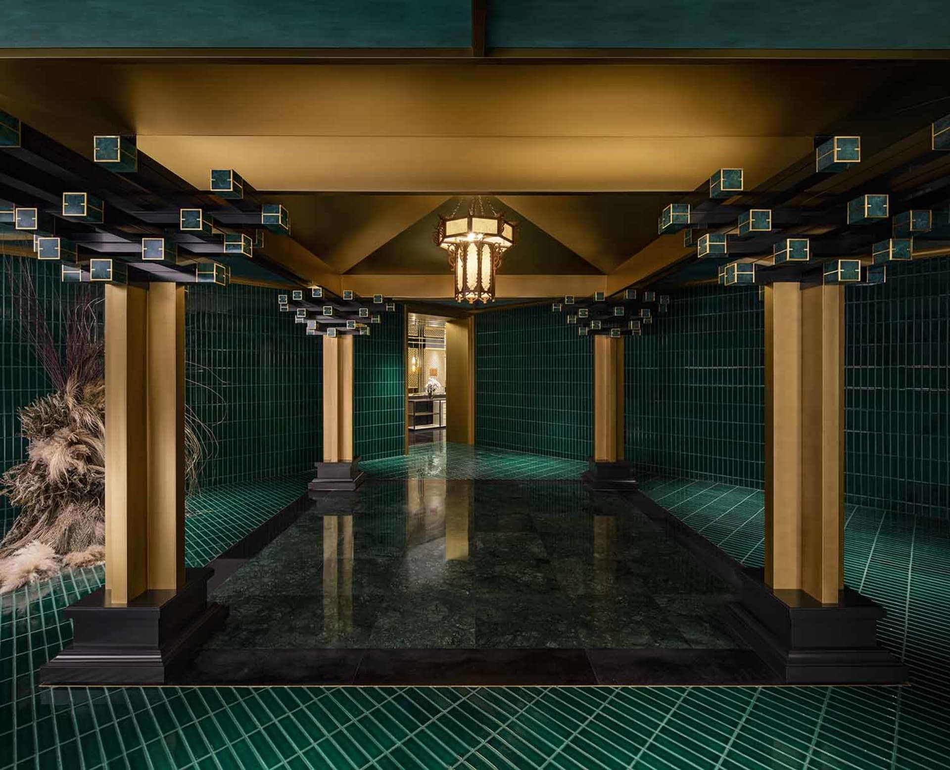 Ornate bathroom with a large tiled floor featuring a checkered pattern in green and gold tones, adorned with gold accents and intricate patterns