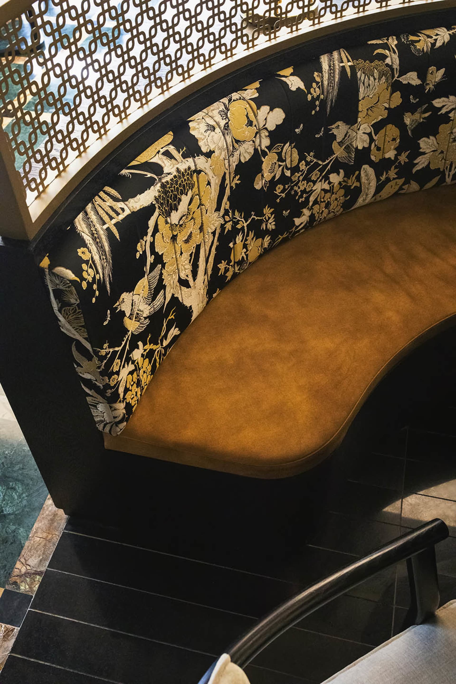 Ornate bench with floral design in a living area, possibly a dining room, with a black frame and Asian-inspired aesthetic
