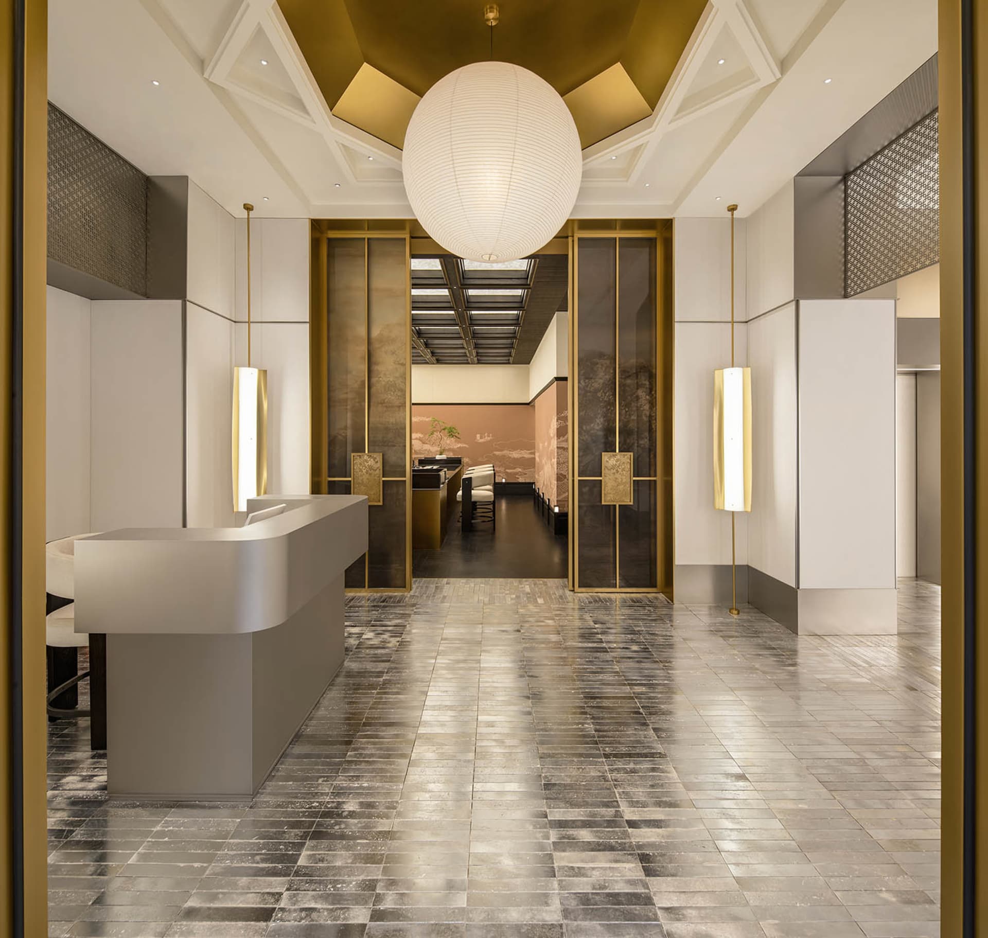 Elegant hotel lobby with marble flooring, gold accents, and high ceilings, featuring a large open space with a dining area and lounge