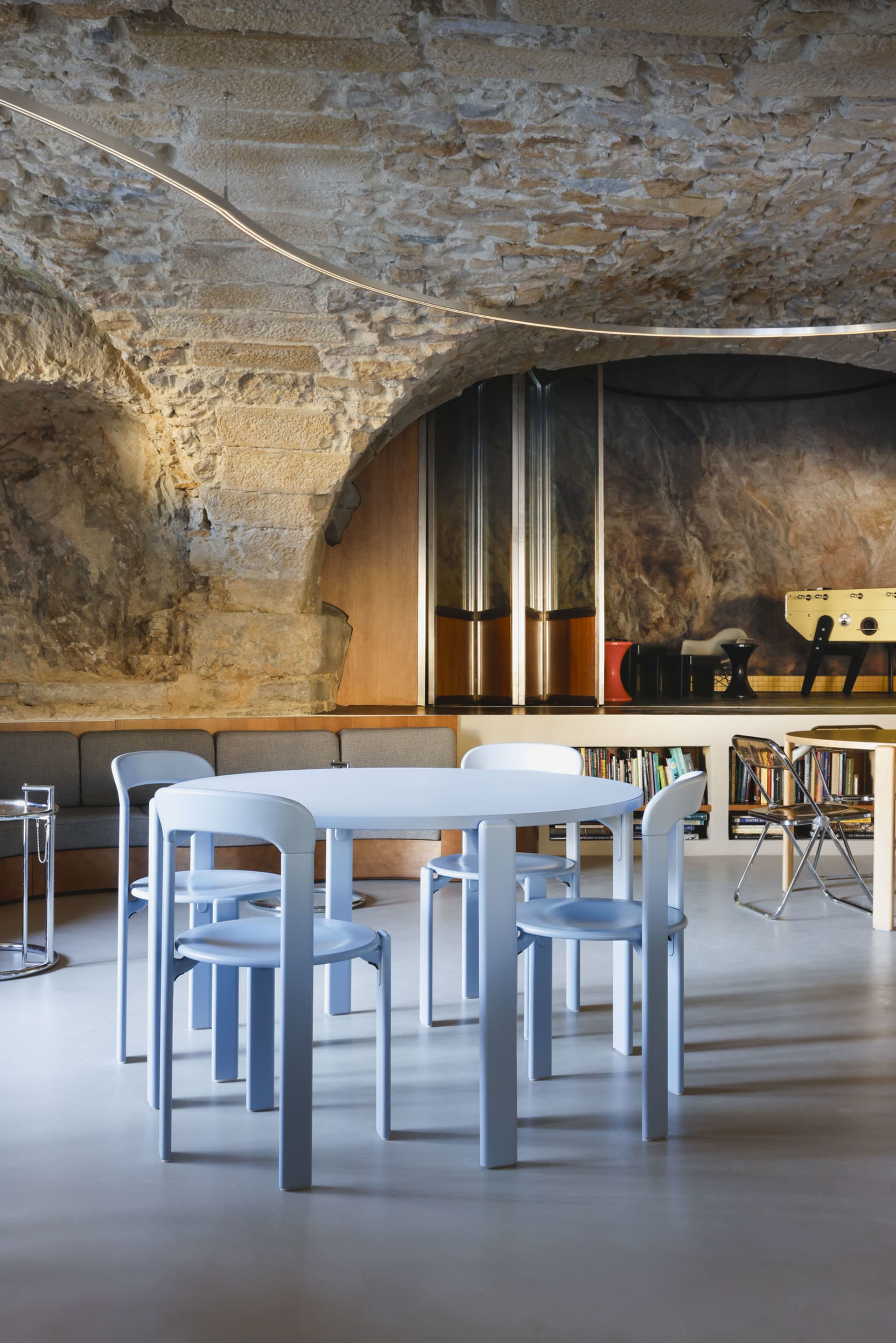 A modern dining space with a white table surrounded by four silver chairs, creating a minimalist atmosphere