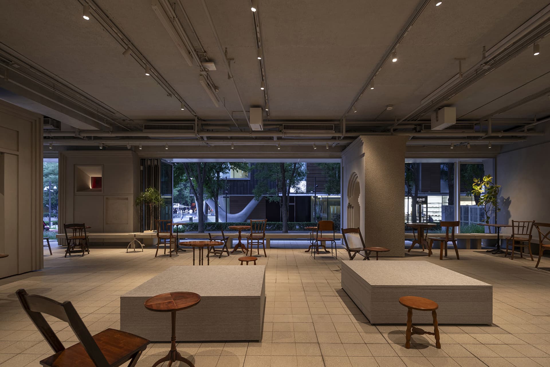 A modern living-dining space with multiple chairs, a large window, and a bright atmosphere, suitable for gatherings or social events