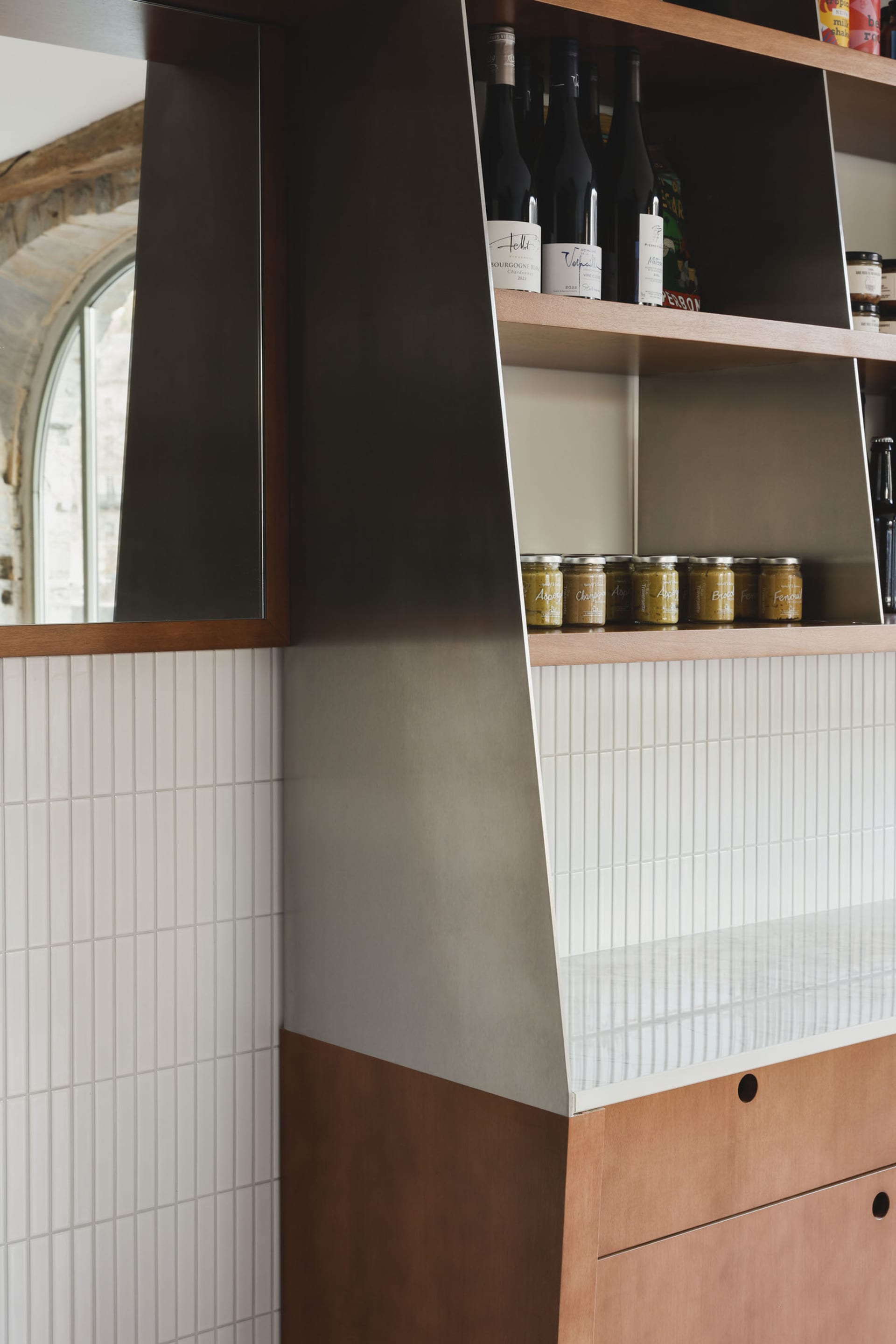 A kitchen area with a countertop featuring various items on display, including bottles and jars of different sizes, creating a well-stocked and ready-to-use atmosphere
