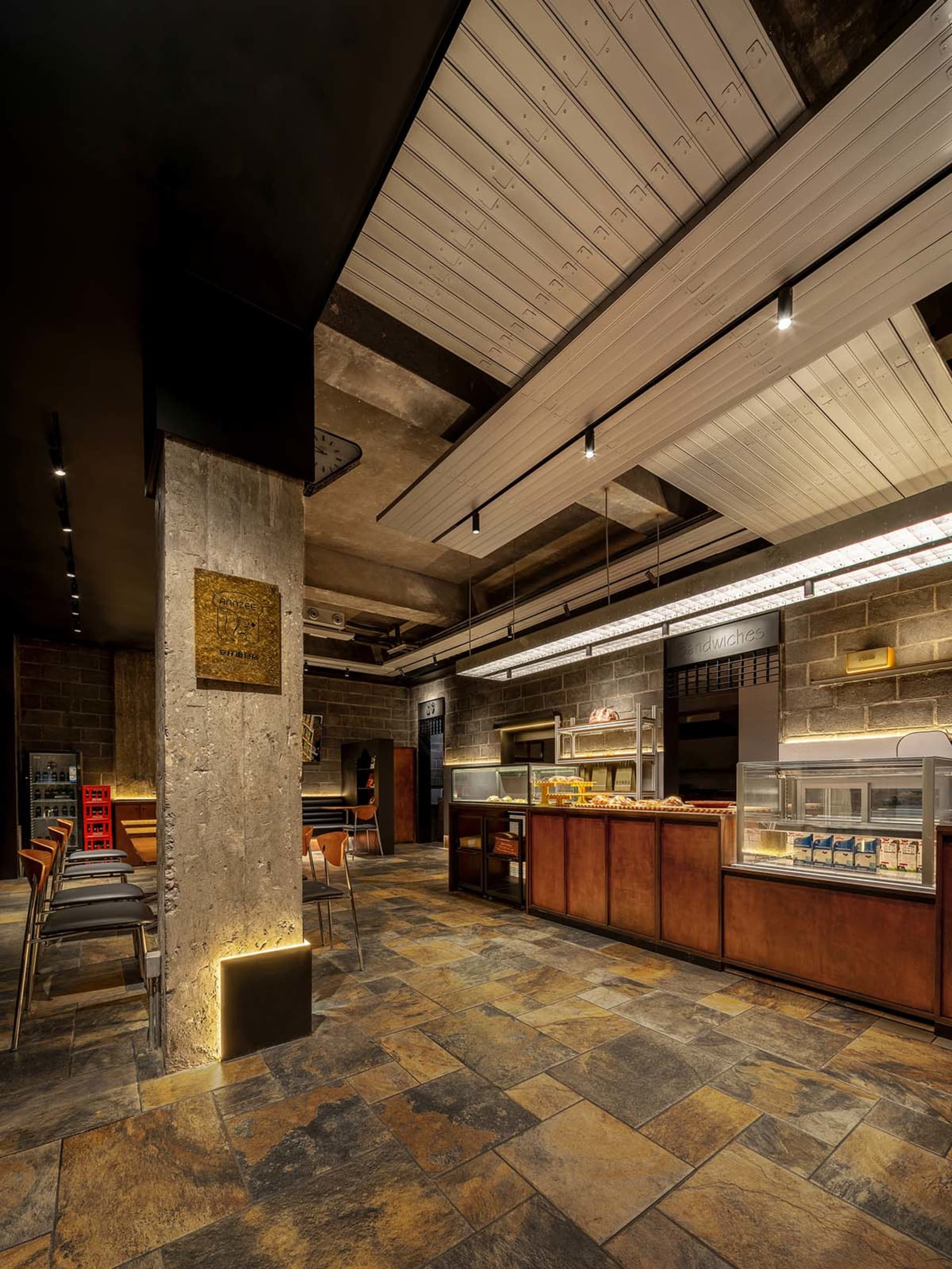 A cozy restaurant with a brick wall, wooden furniture, and metal accents, featuring a mix of modern and traditional elements, with various lighting sources creating a warm ambiance