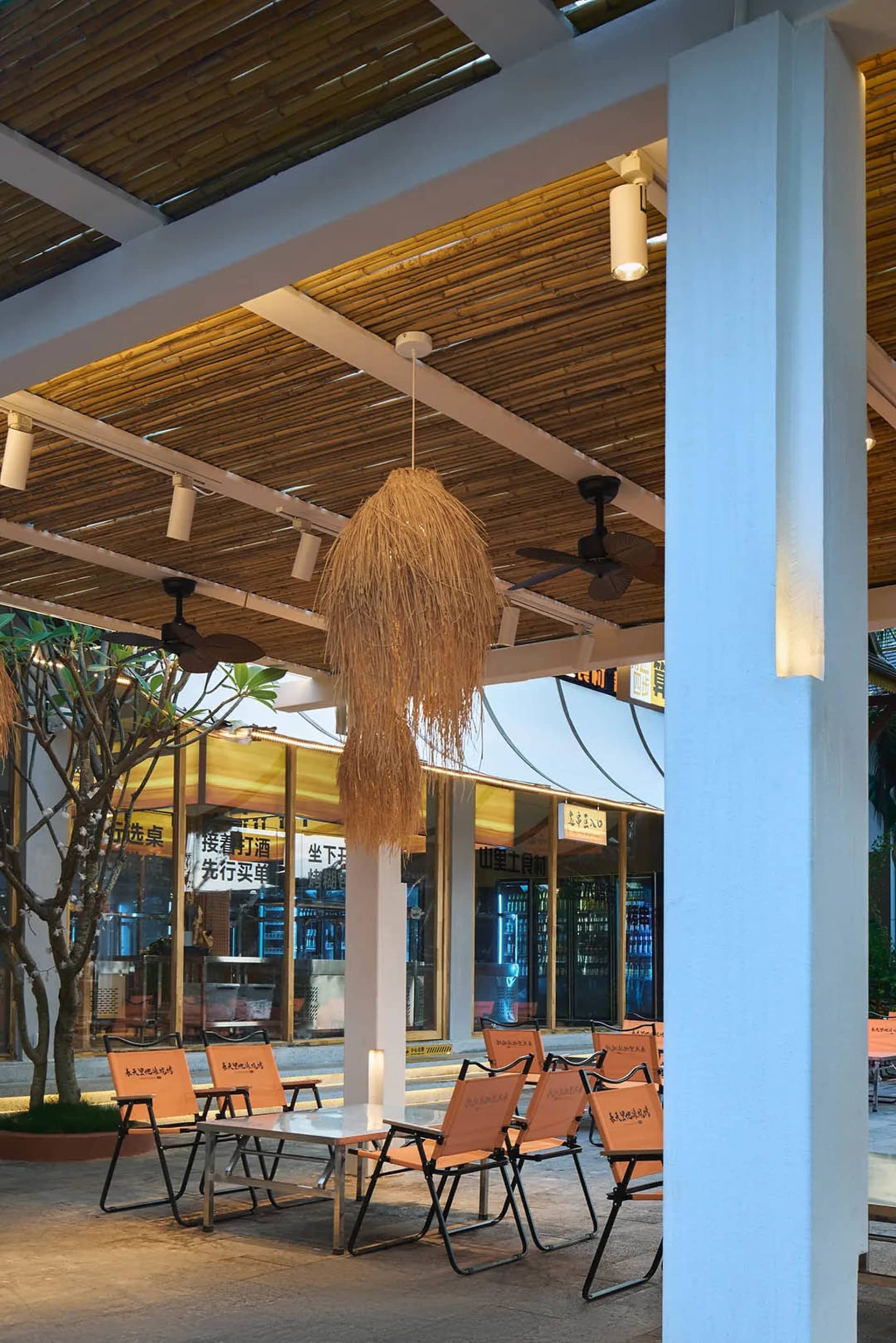 A restaurant patio with several wooden chairs in different positions, creating a relaxing and inviting atmosphere