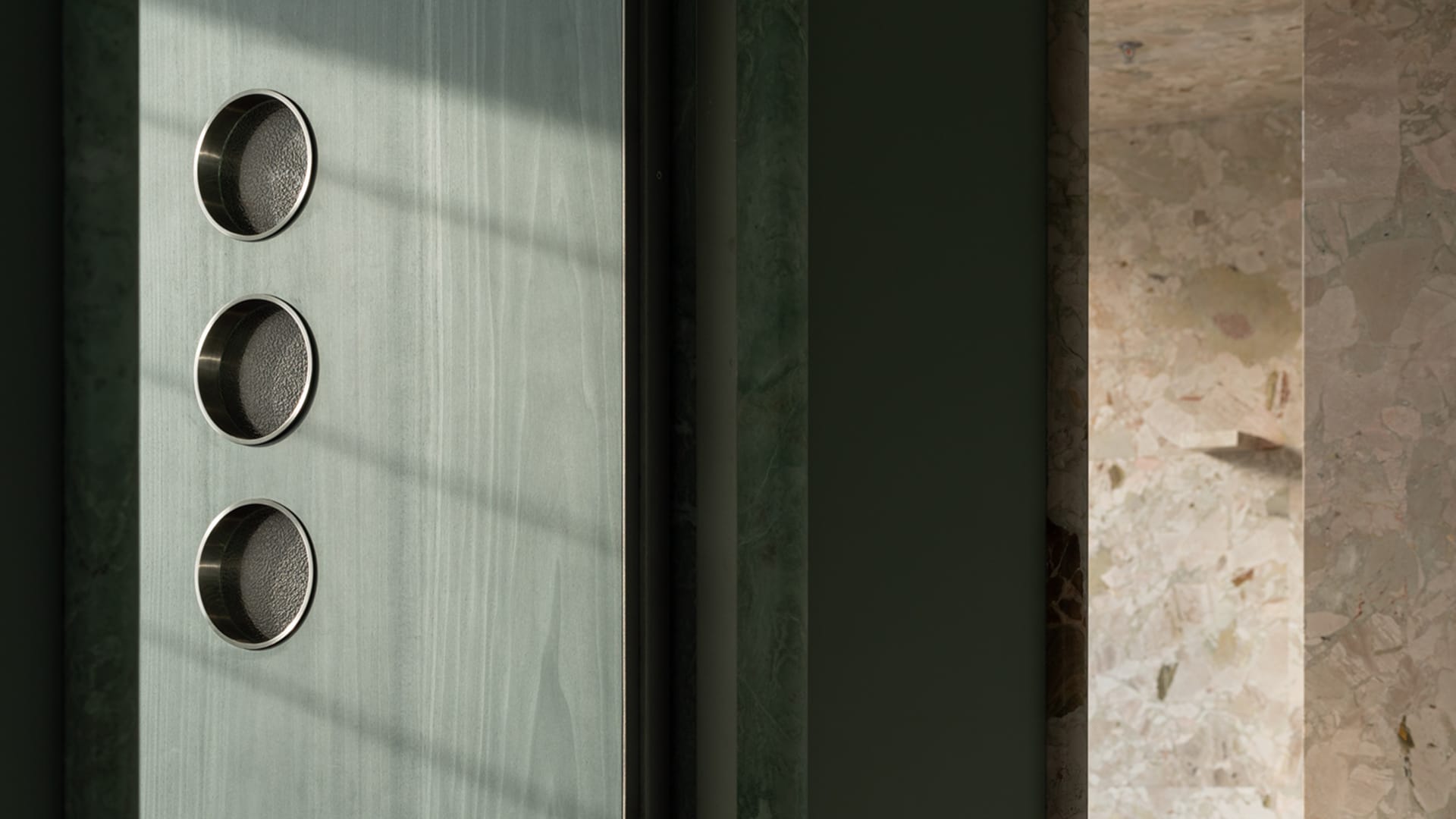 A bright and inviting hotel lobby with a marble wall, a glass doorway, and natural light from the glass panel