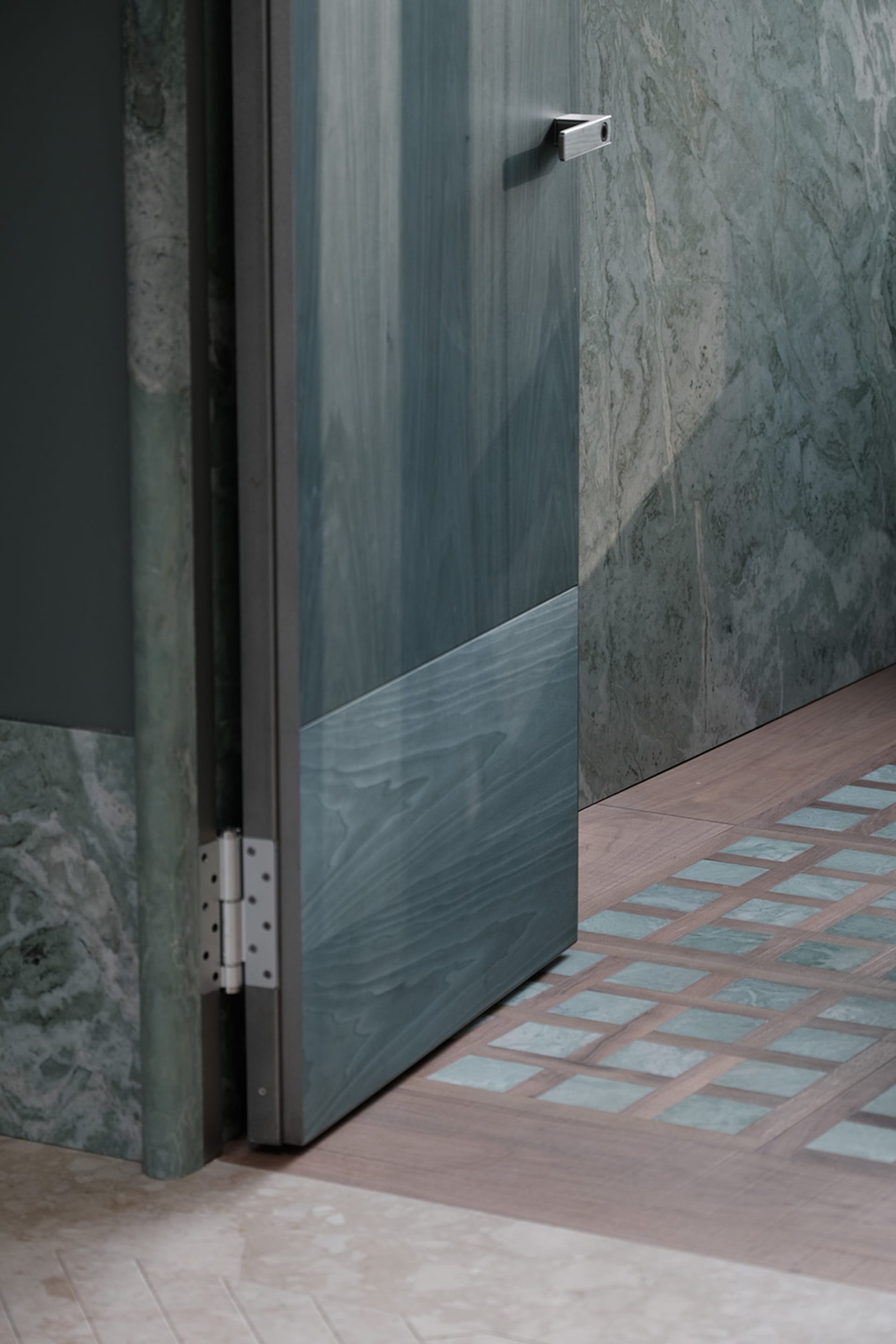 A wooden door with a glass window leads to a private bathroom, offering a glimpse into the space beyond