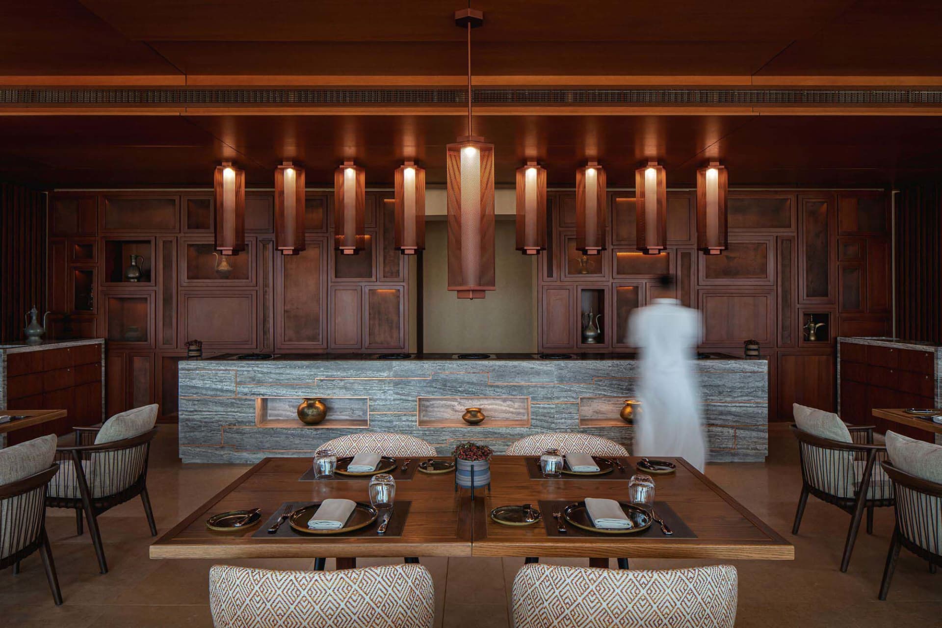 Warm and inviting kitchen space with wooden elements, stone countertops, a dining table, and decorative items