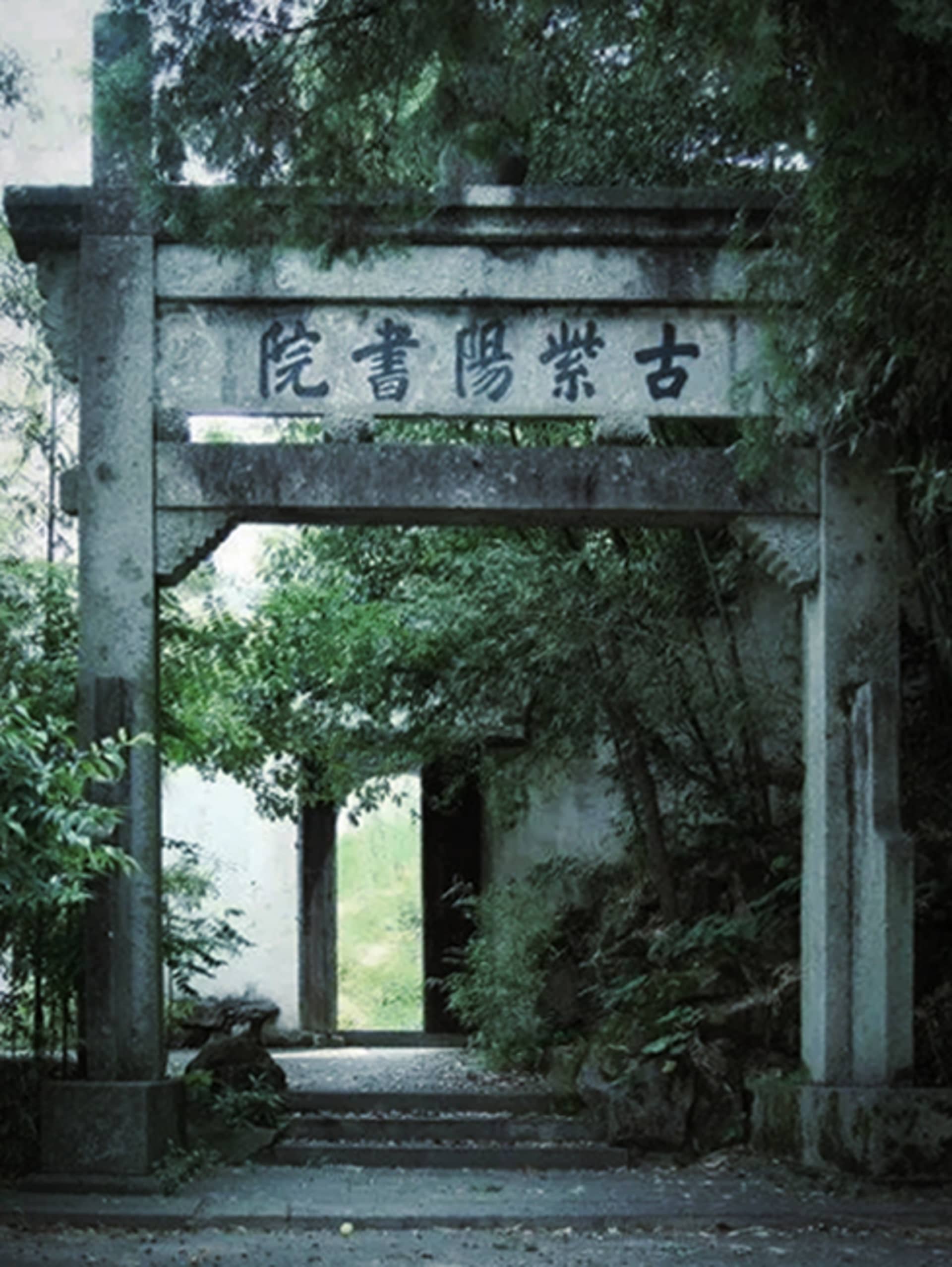 寧靜亞洲風格入口處，石拱門上刻有漢字，周圍綠樹環繞的靜謐庭院