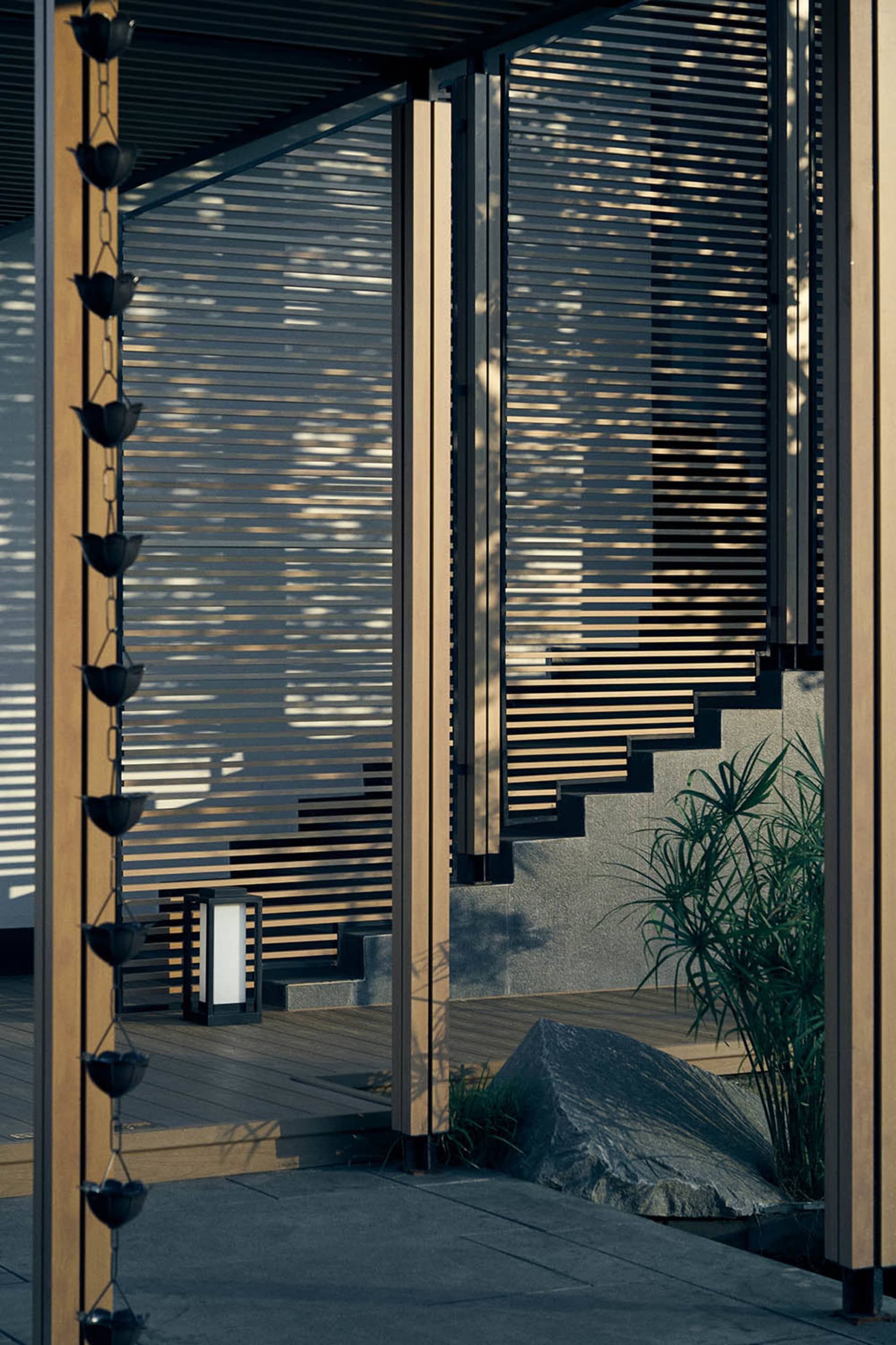 A traditional house with a wooden staircase, large windows, and a rock in front, conveying comfort and elegance