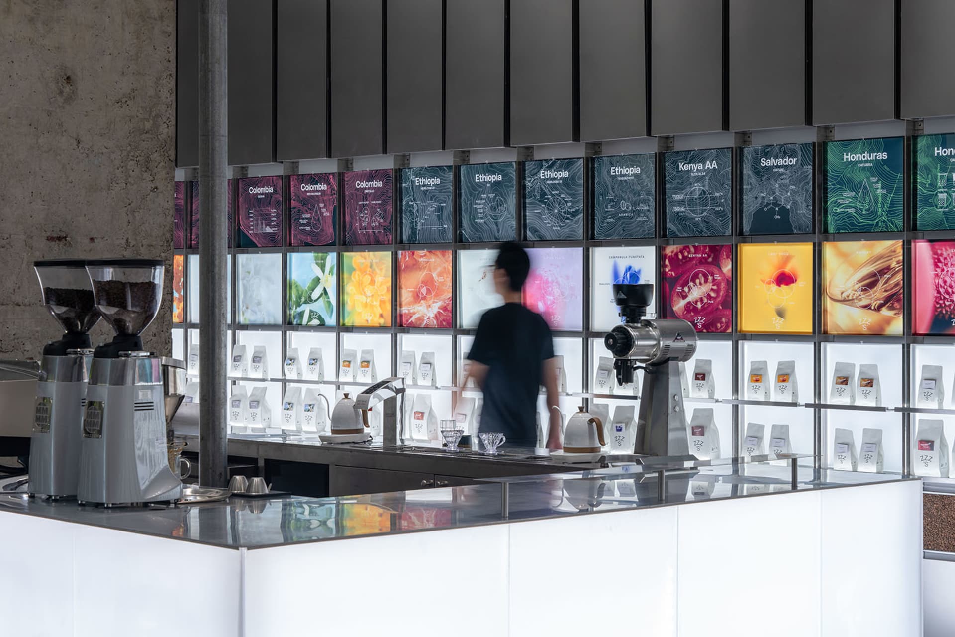A bustling coffee shop with modern displays, TV screens, and comfortable atmosphere, featuring a counter and various equipment