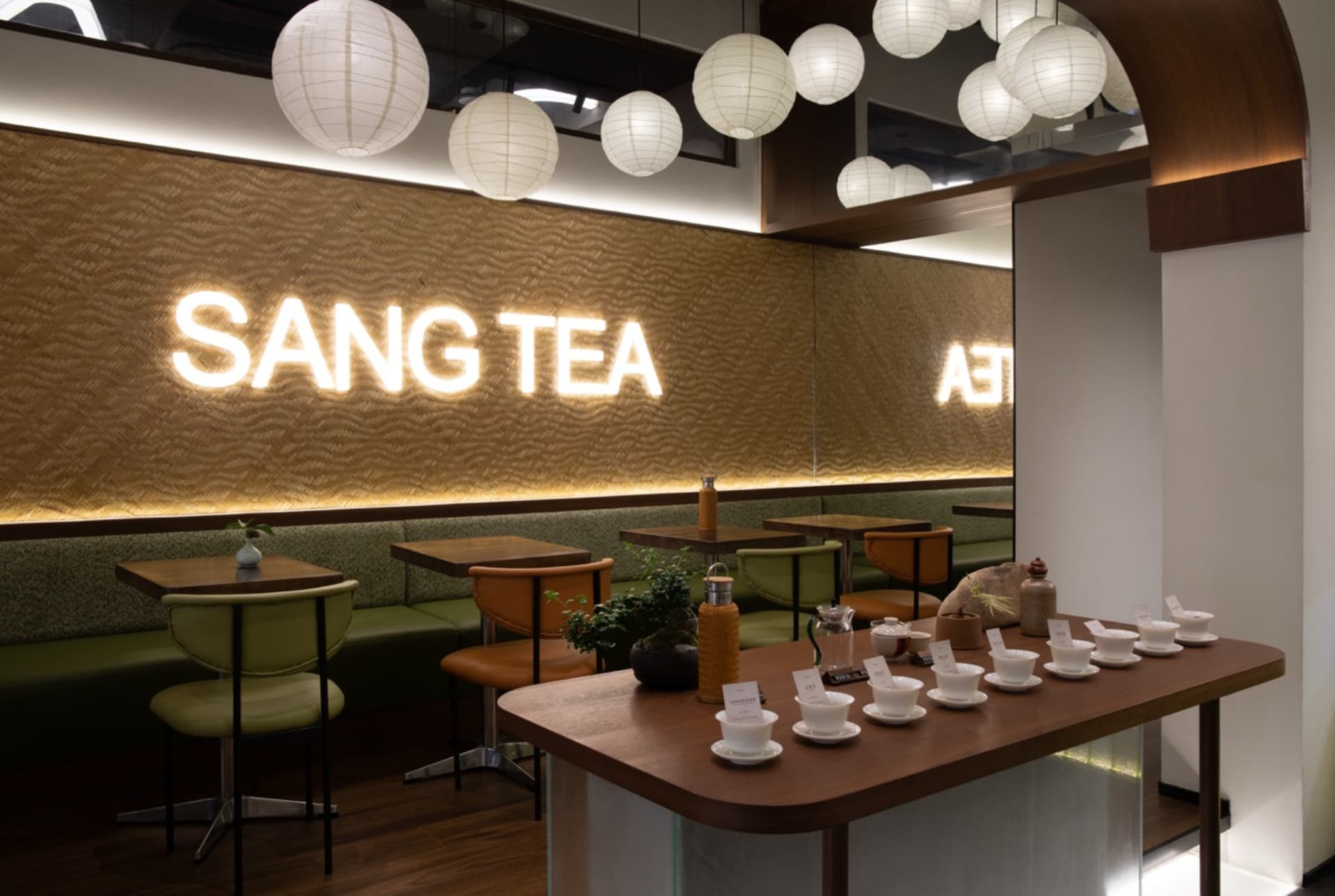 溫馨餐廳內部，配有木質餐桌、椅子與杯具，周圍環繞暖光燈與舒適氛圍