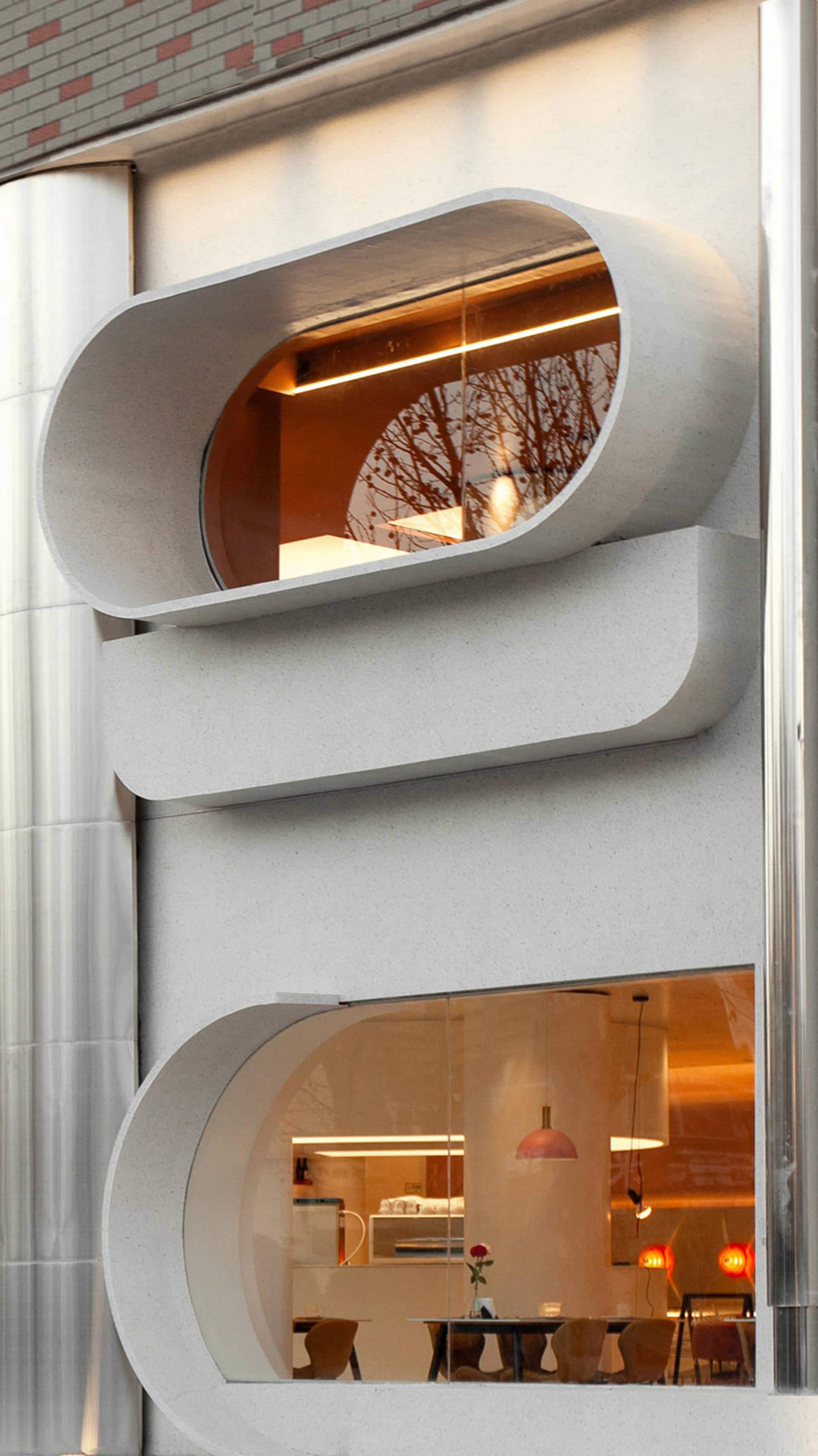 Interior view of a contemporary office space with a metal spiral staircase, concrete walls, and a sense of practicality and efficiency