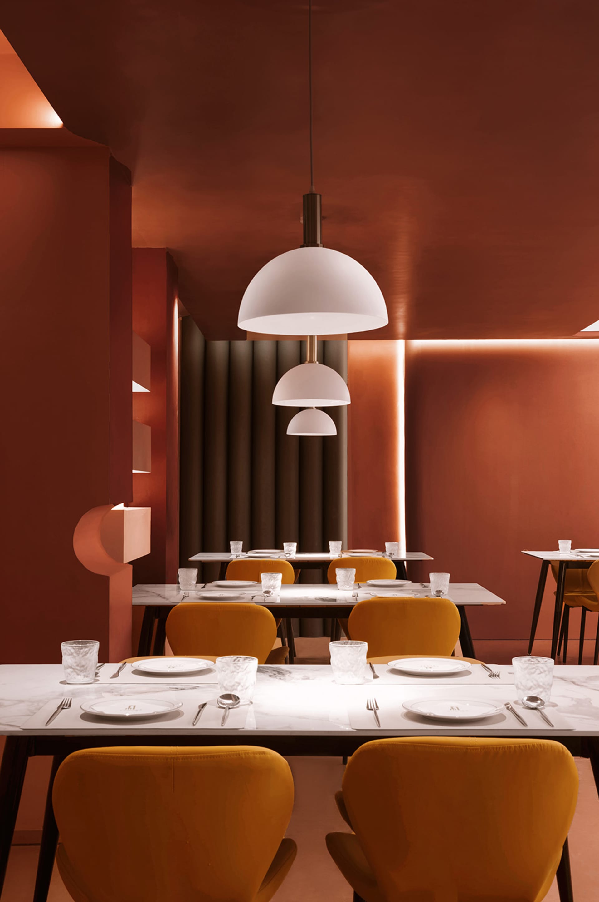 Warm and inviting dining space with a long table, yellow chairs, and soft lighting, surrounded by wood elements