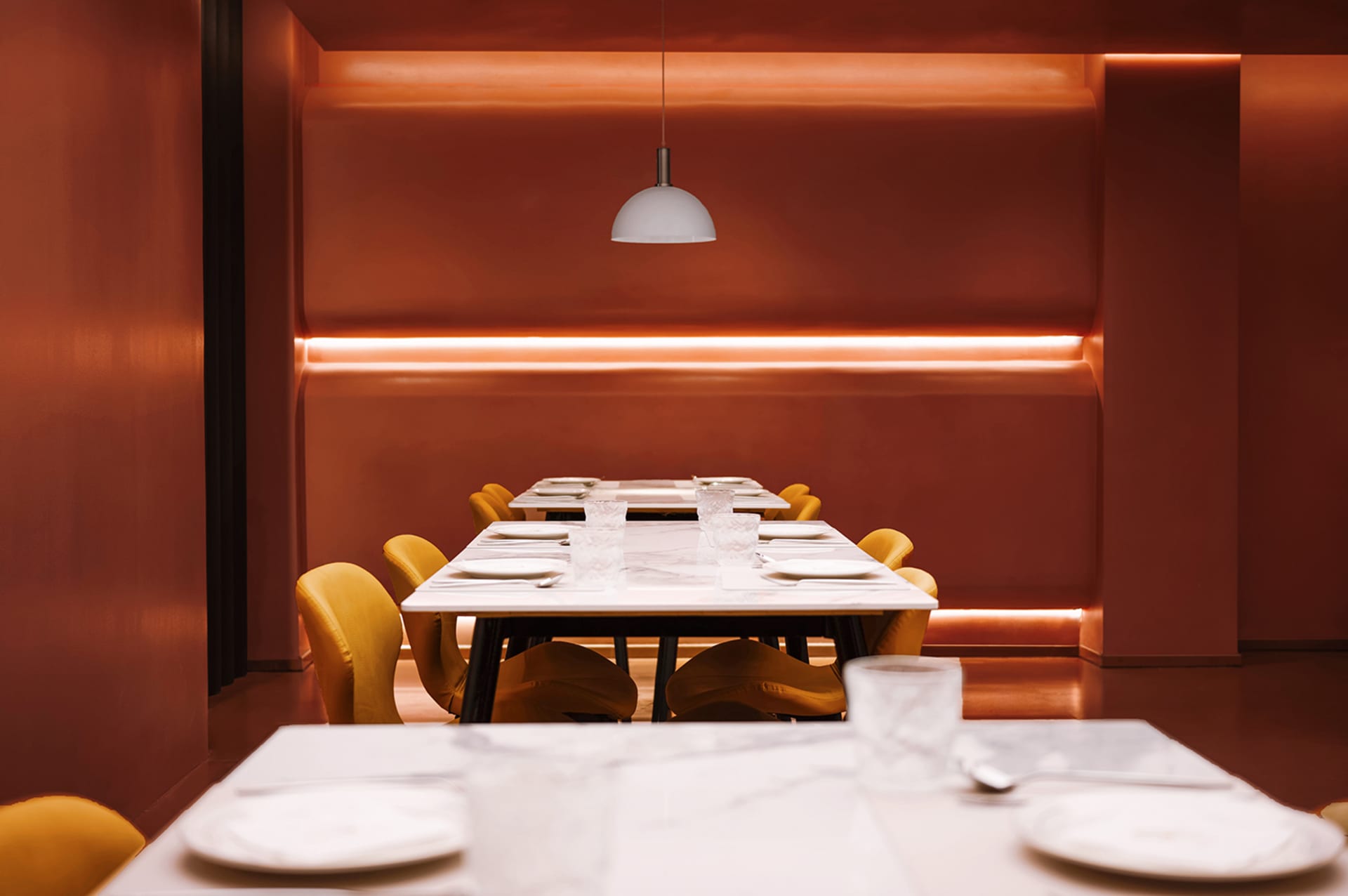 A formal dining area with a long wooden table and chairs set up for a meal, surrounded by a warm and inviting atmosphere