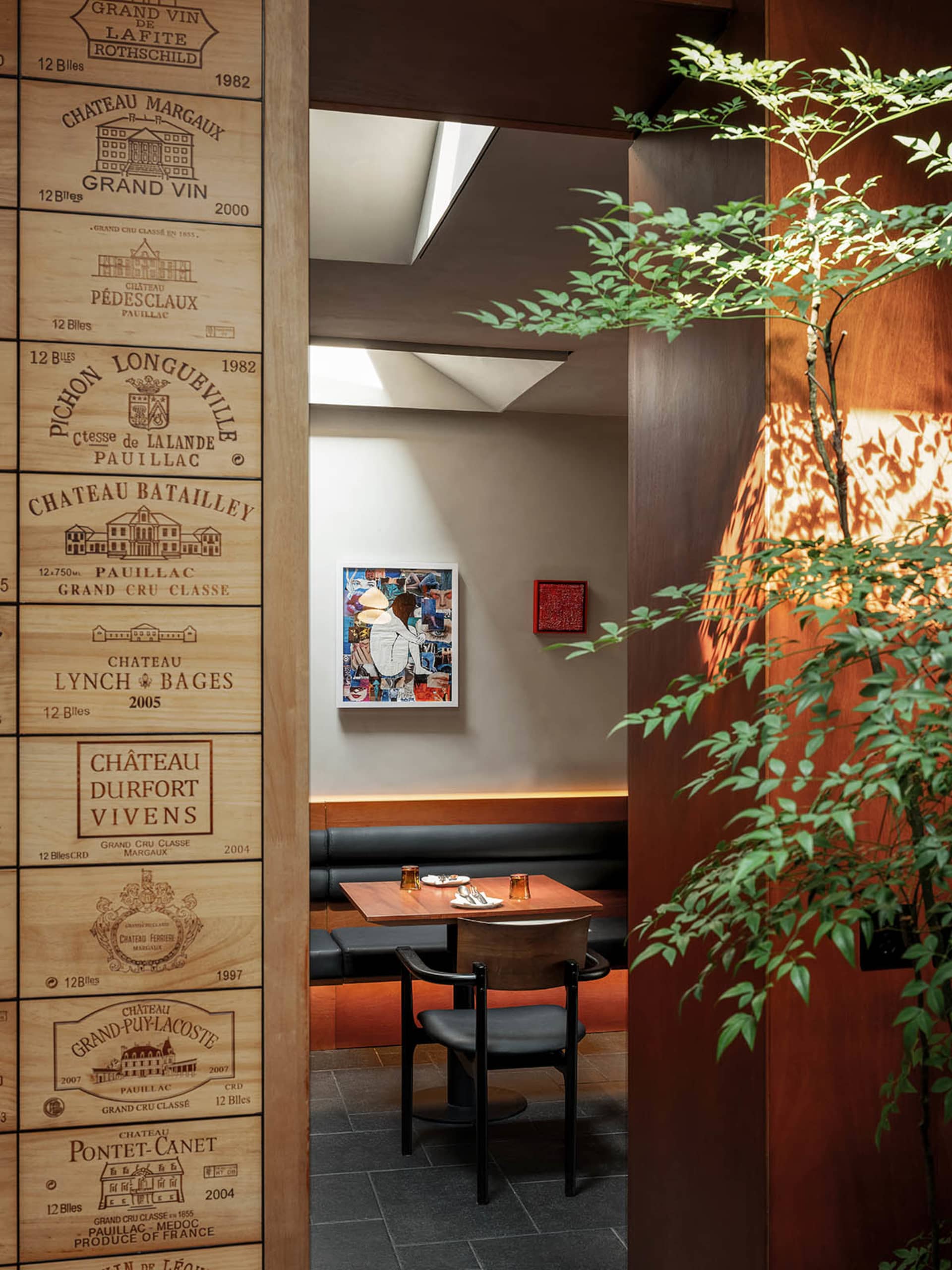 A dining area with tables and chairs, surrounded by wine bottles on the walls, creating a sophisticated ambiance