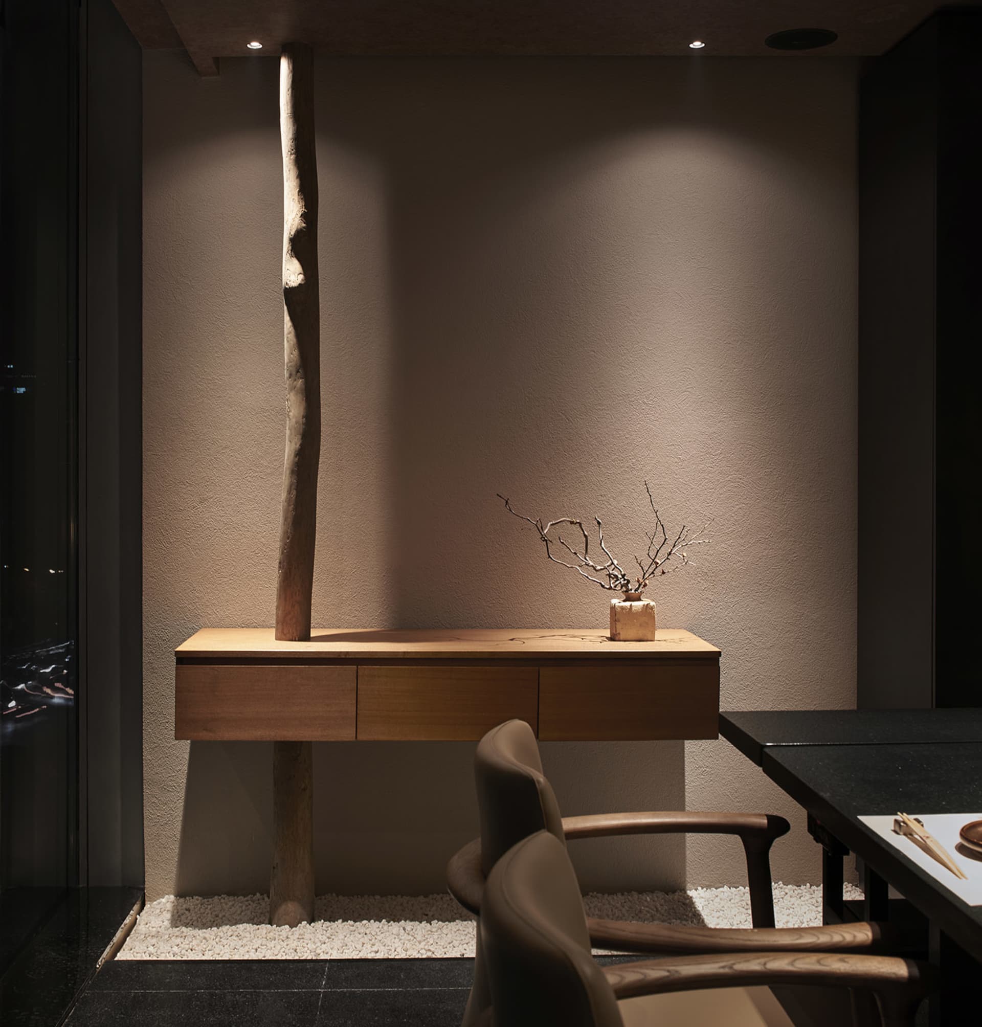 A warm and inviting interior space with a wooden table, two chairs, and natural light from windows