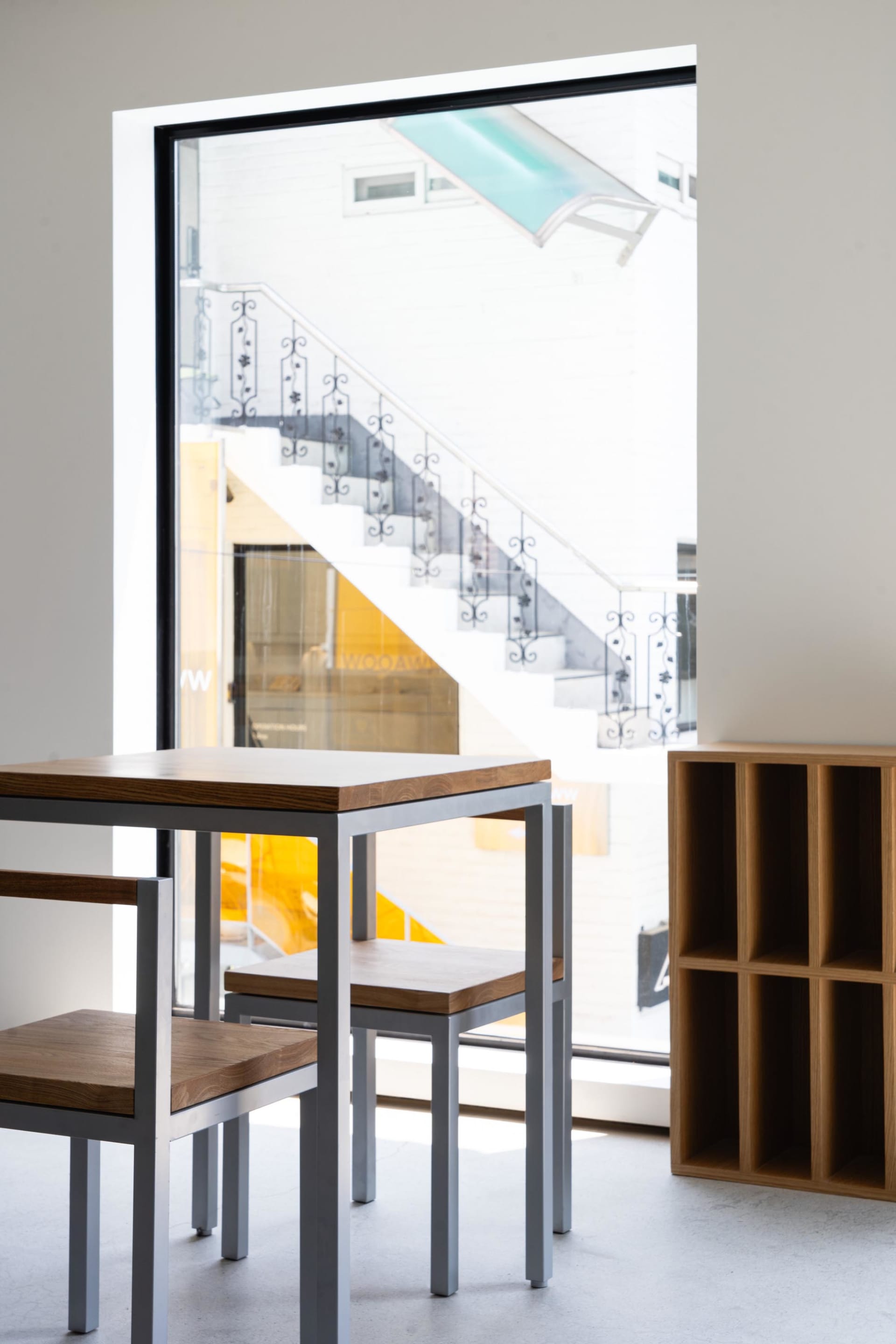 Elegant interior stairwell with wooden stairs, metal railing, and two chairs for guests to sit and rest