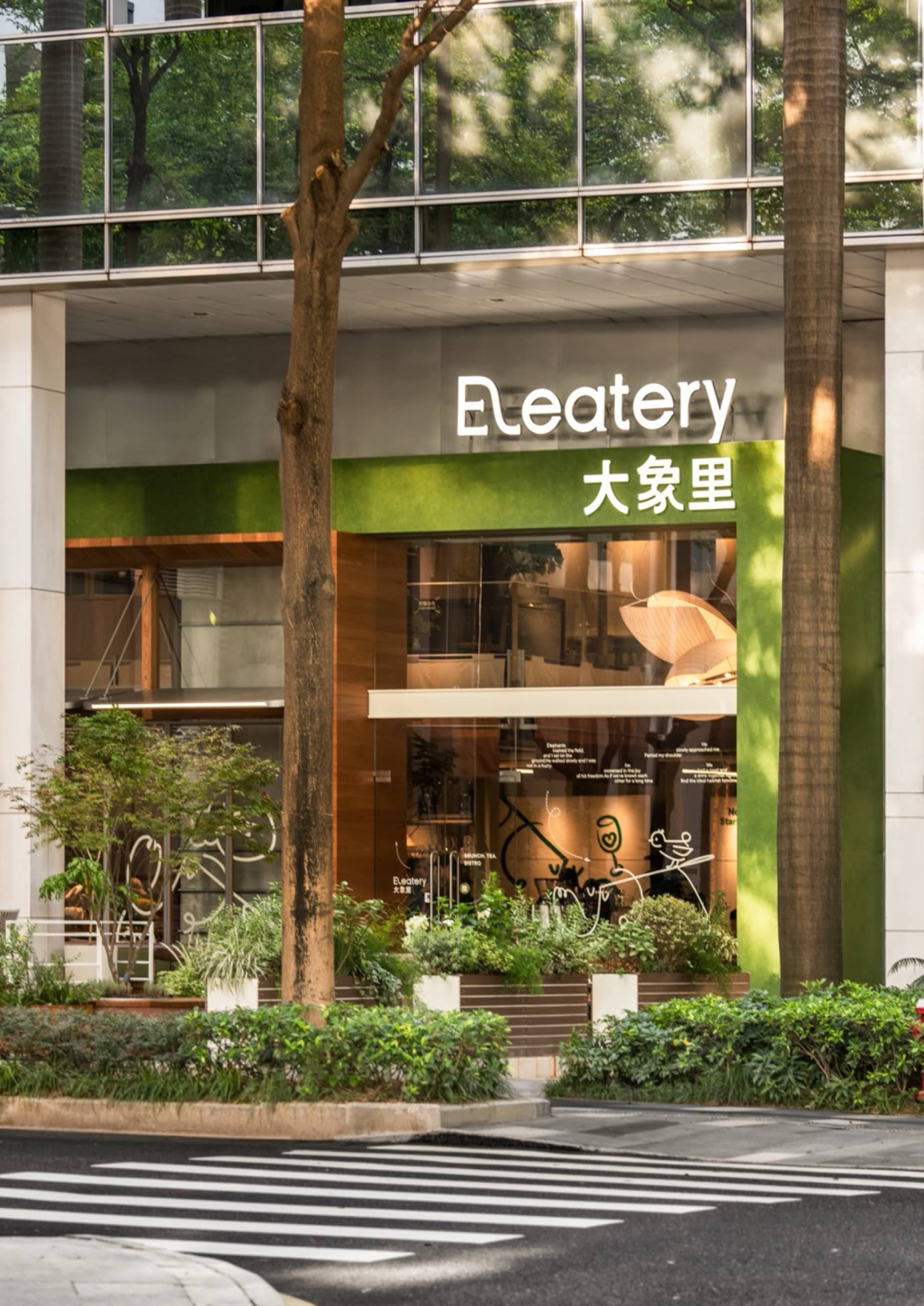 A well-designed Asian restaurant with a green facade, natural light, and potted plants, featuring a dining area with chairs and tables