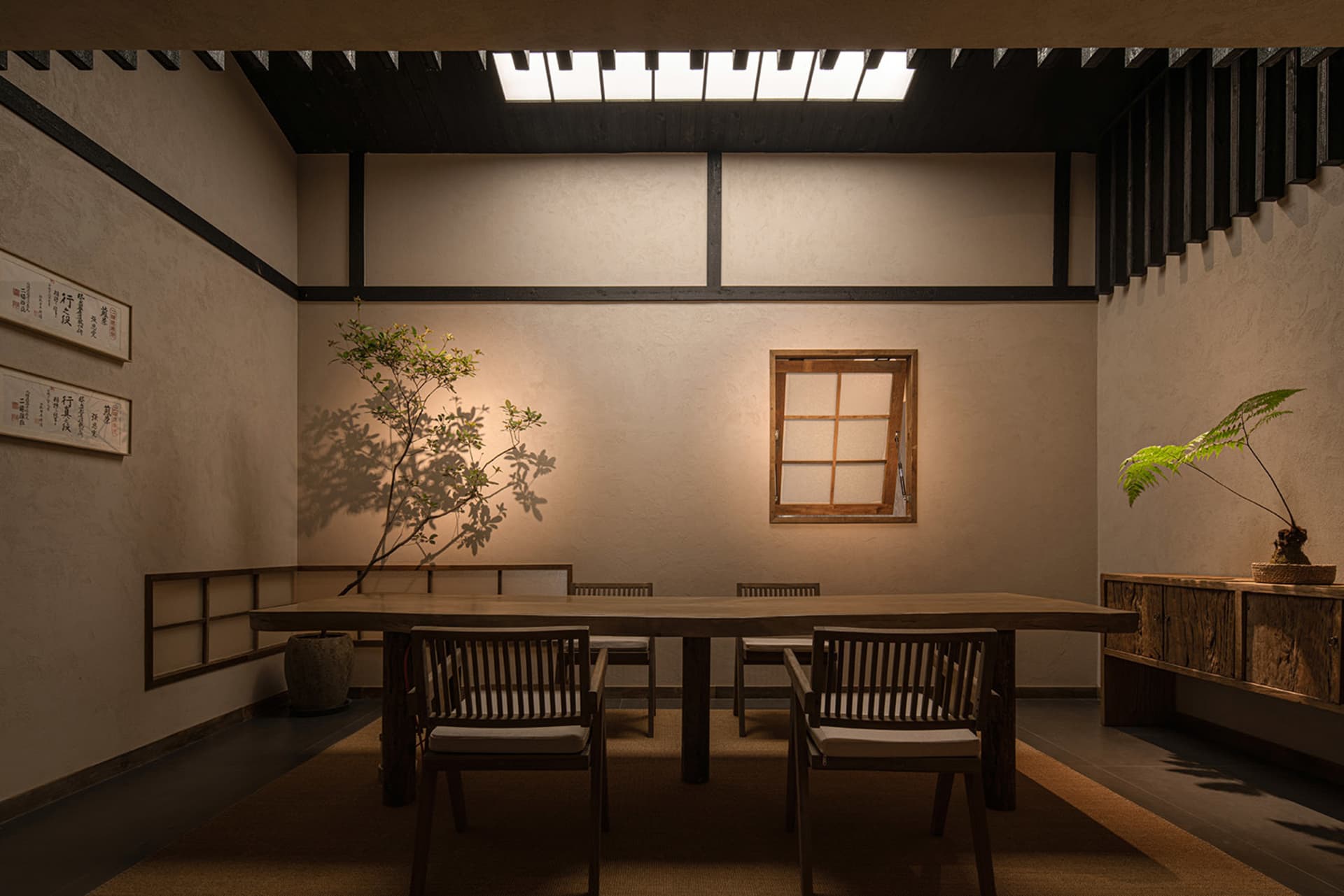 Dimly lit dining area with a wooden table and four chairs, creating a cozy atmosphere