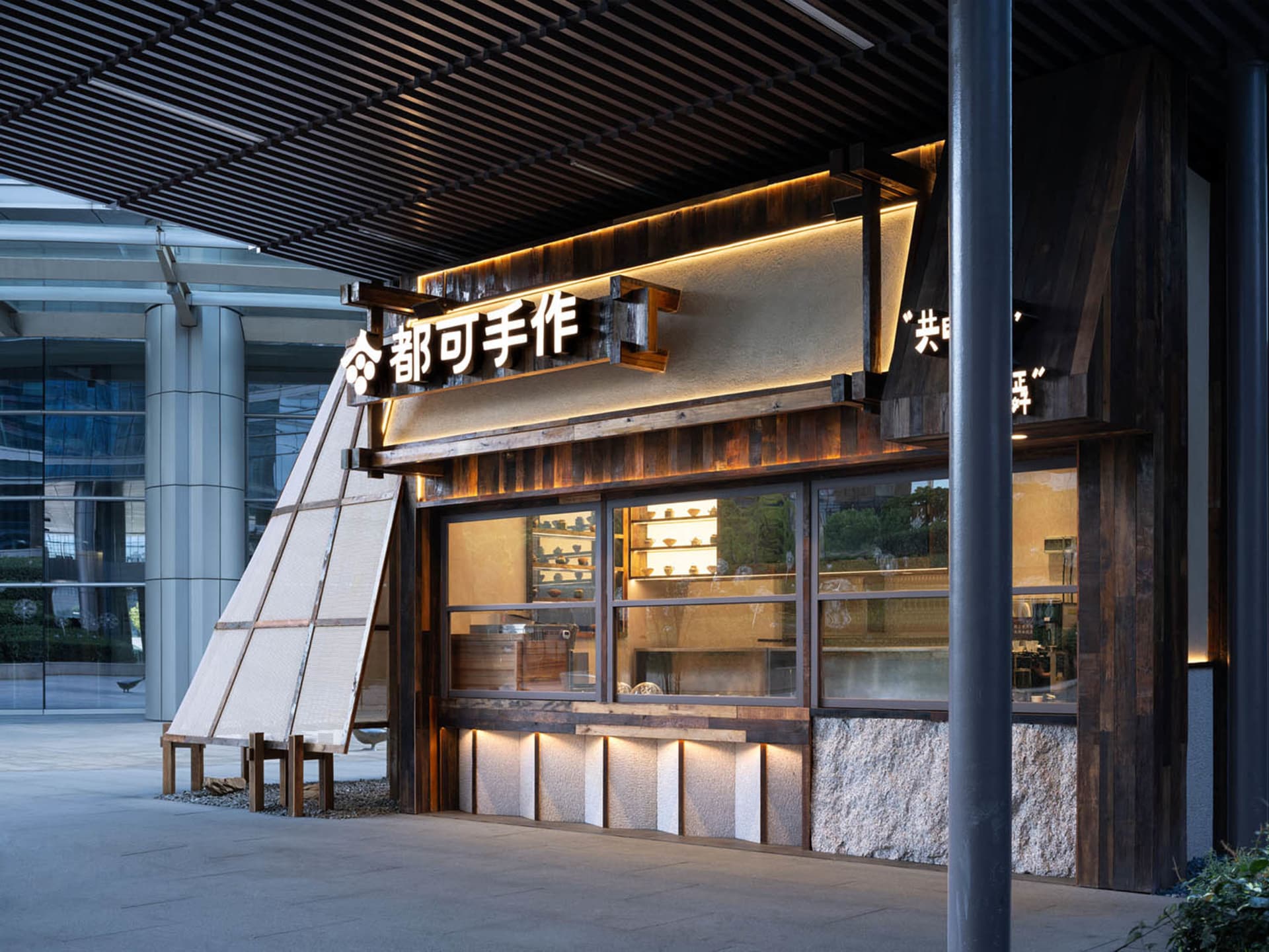 A restaurant with a wooden exterior and a large sign, featuring a mix of wood and stone elements, warm atmosphere, and traditional-modern design