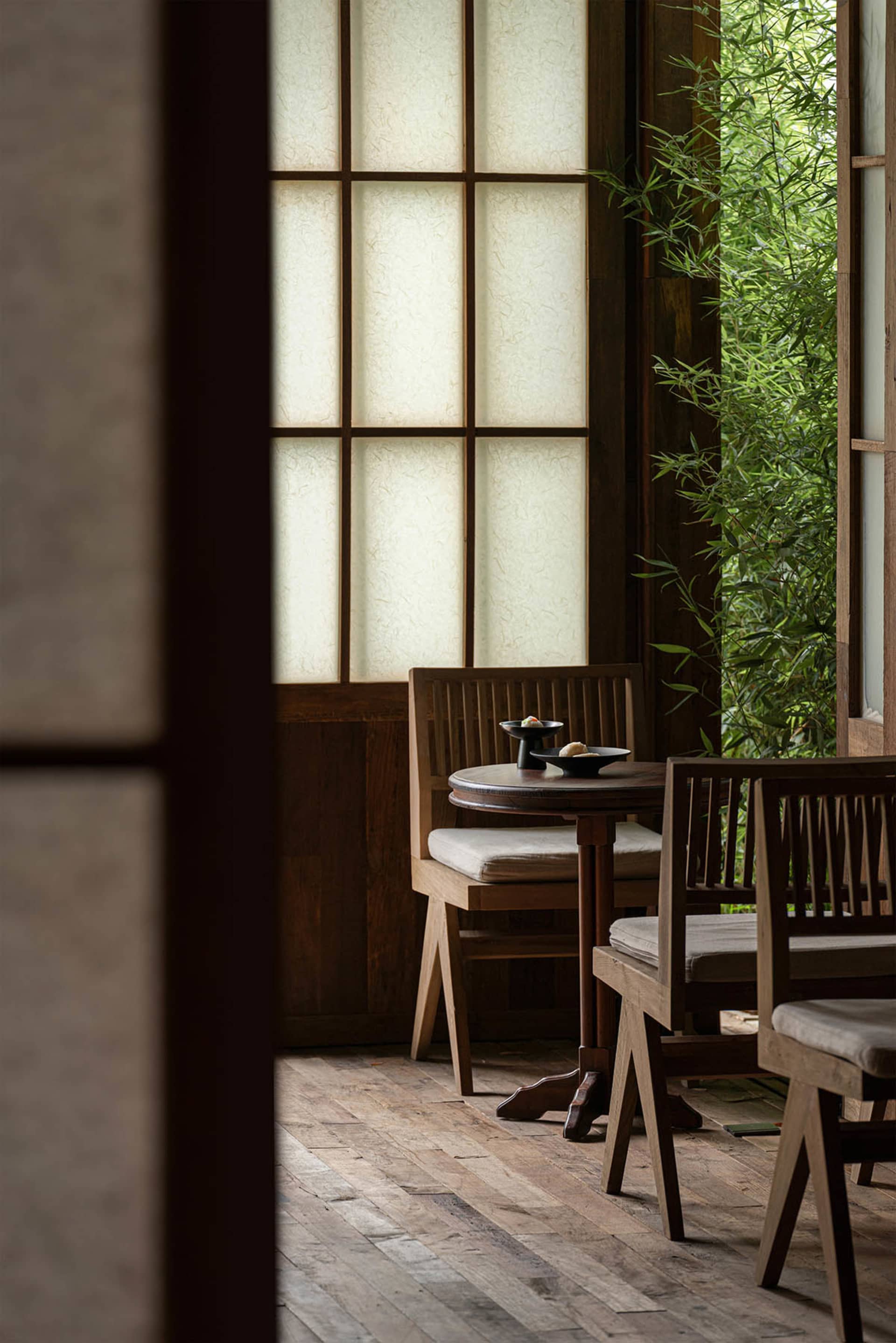 A warm and inviting dining area with wooden chairs and tables arranged around a central table, creating a comfortable seating arrangement