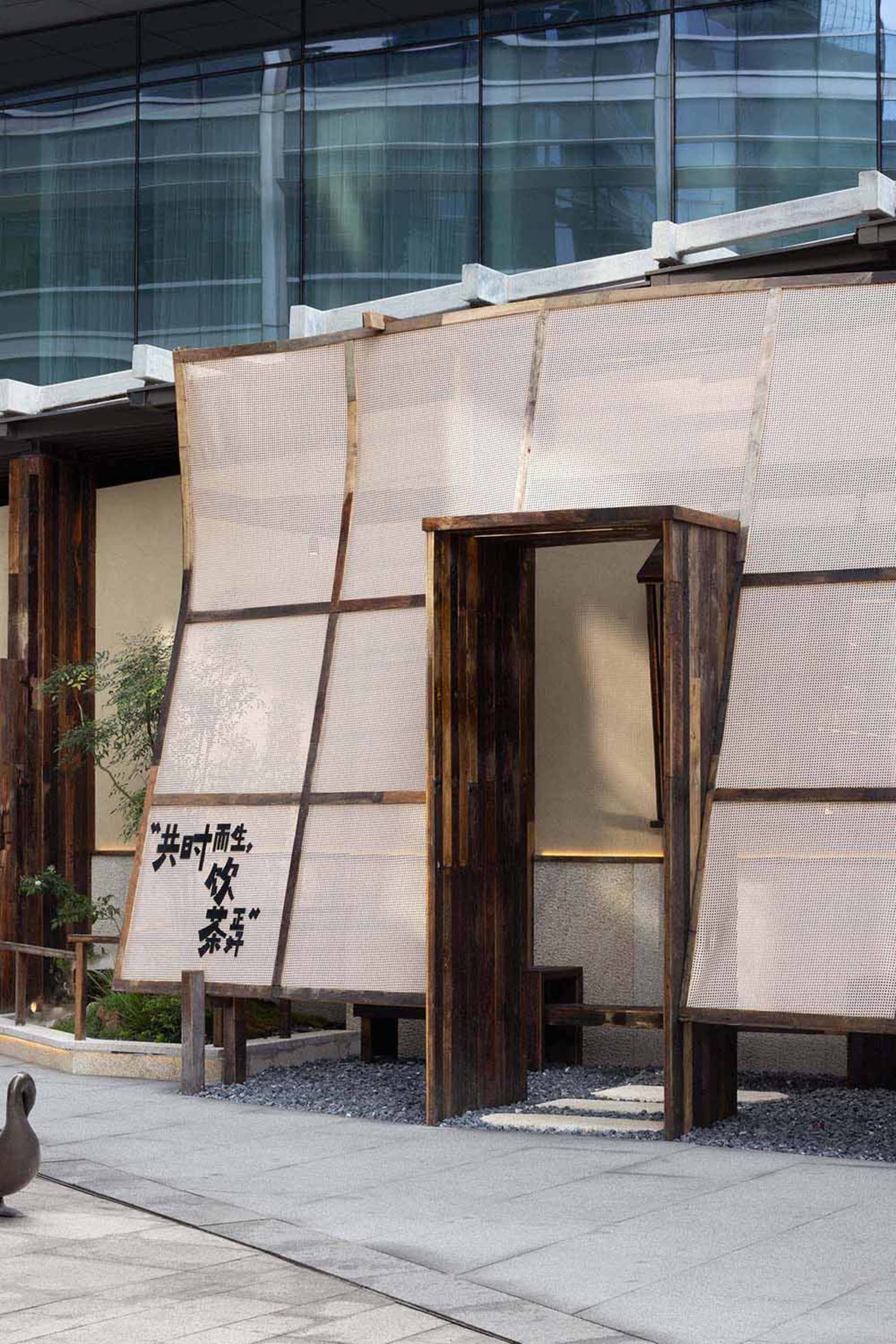 A photo of an Asian-style building with a wooden structure and a large window, featuring a mix of wood and stone elements, with ample natural light entering the space