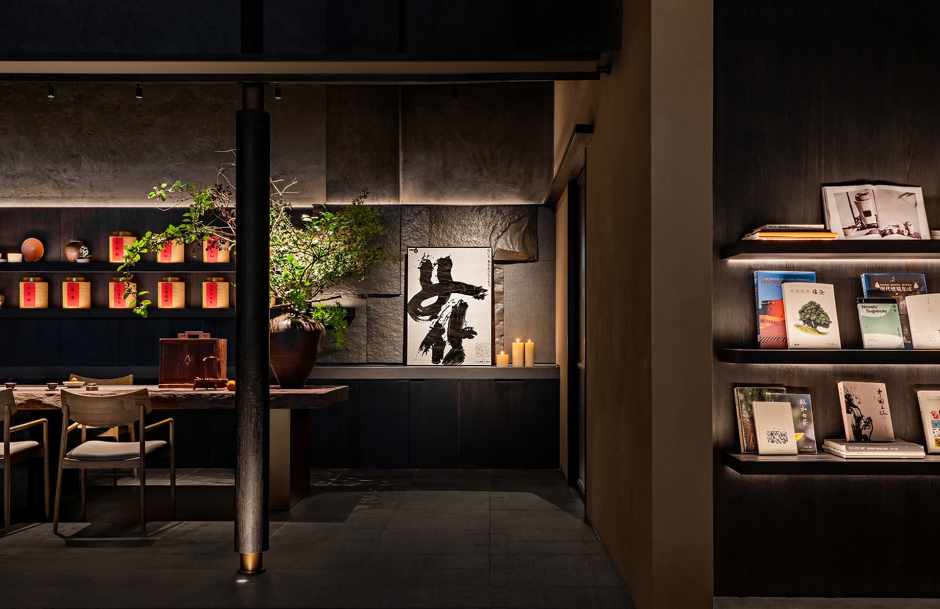 Cozy Asian-inspired living space with a black and white theme, featuring a dining table, bookshelf, and potted plants