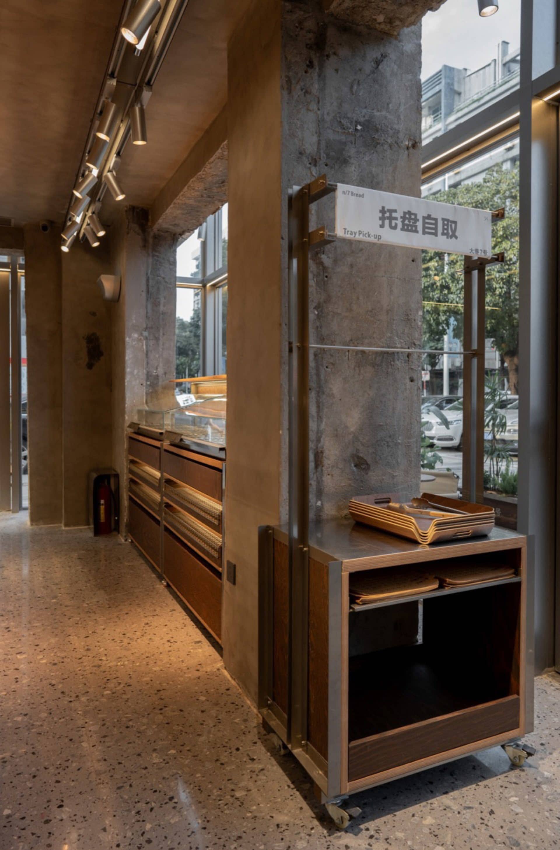Casual dining space with concrete walls, a modern and industrial feel, and a counter with books, cups, and bowls on display