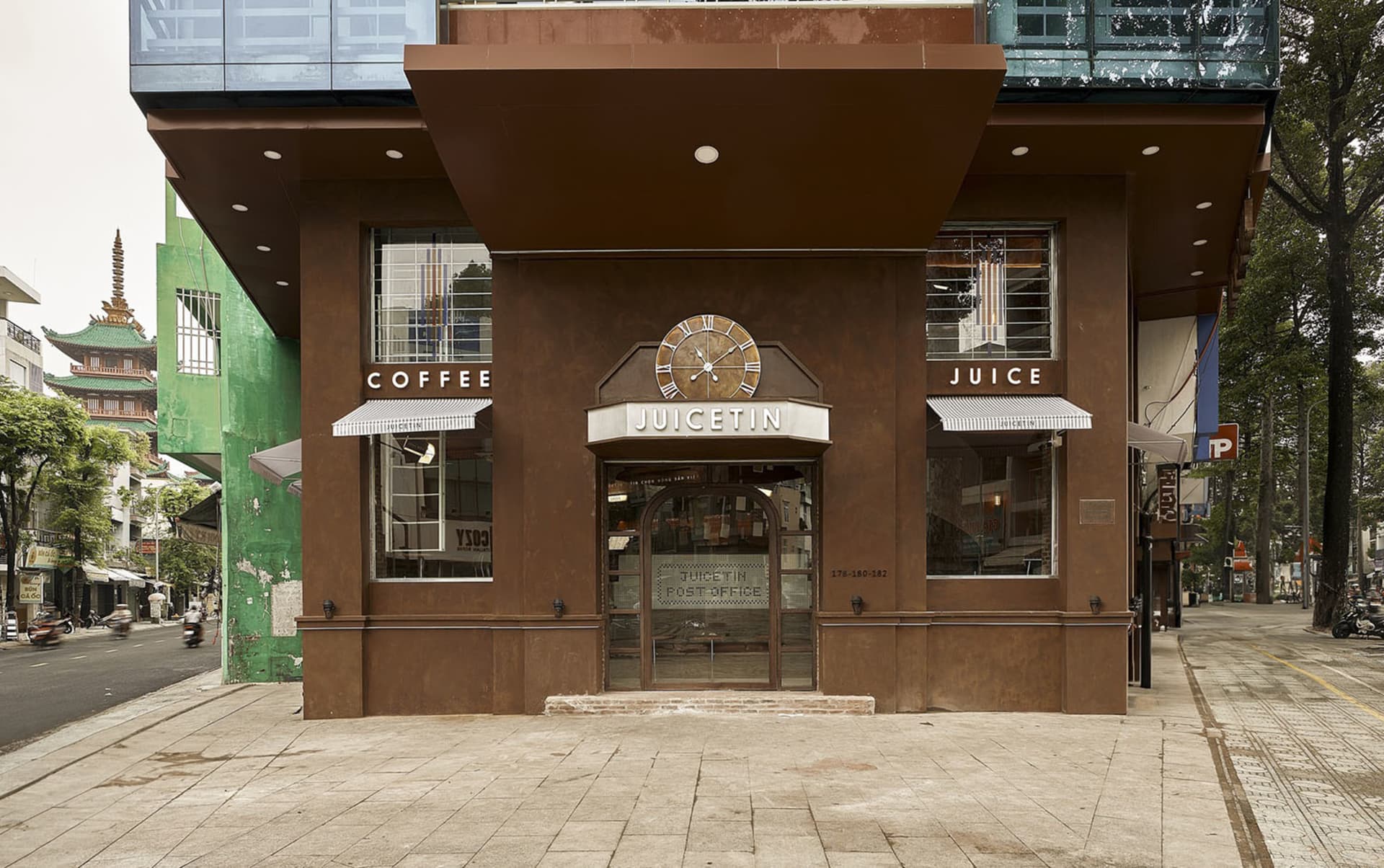Exterior view of a brown building with a clock on its side, a storefront window, and a cozy atmosphere