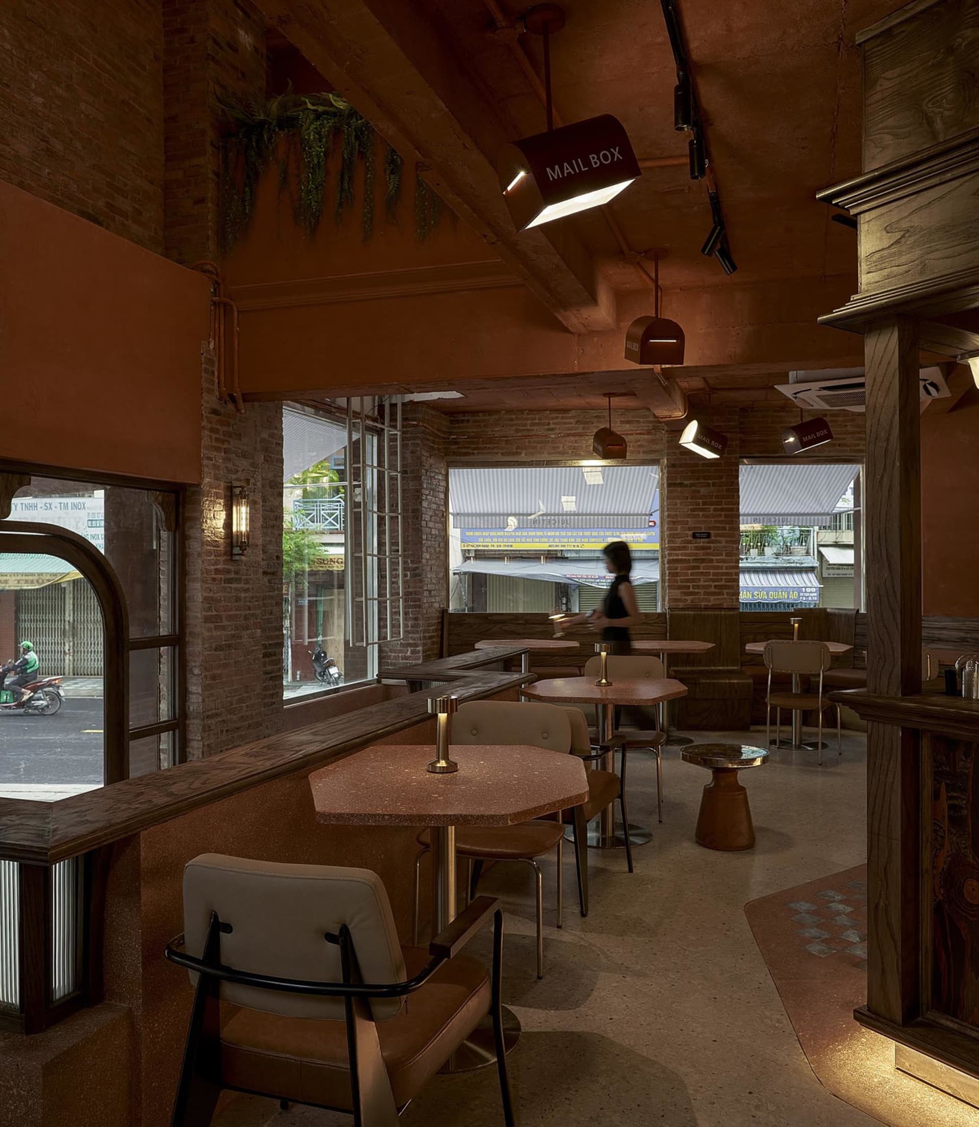 A warm and inviting cafe with wooden tables, chairs, and potted plants, perfect for socializing and relaxation