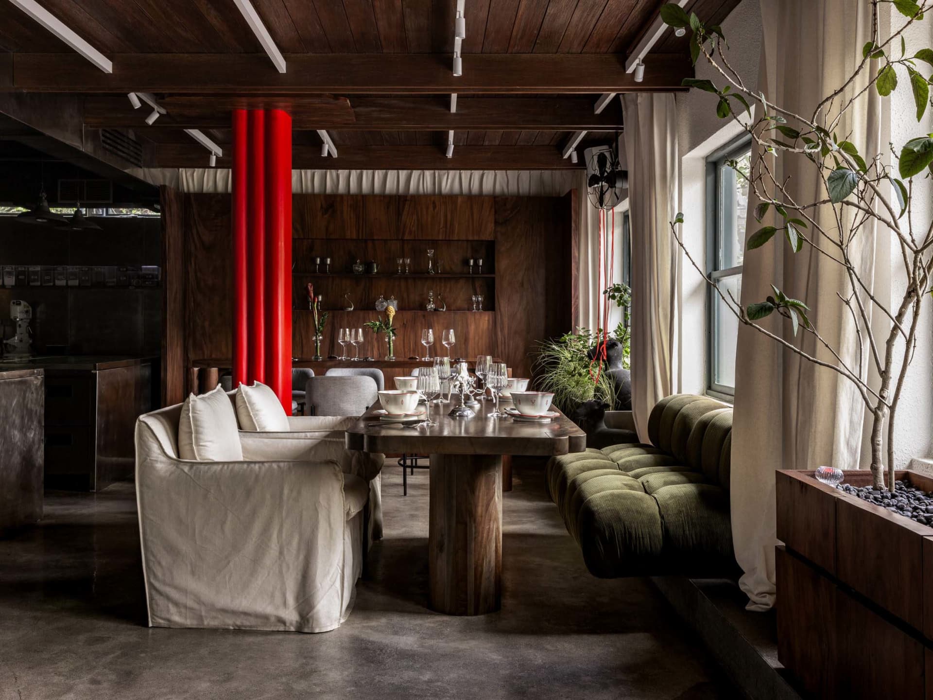 Modern dining and living space with a dining table, chairs, and a couch, set up for a meal or gathering