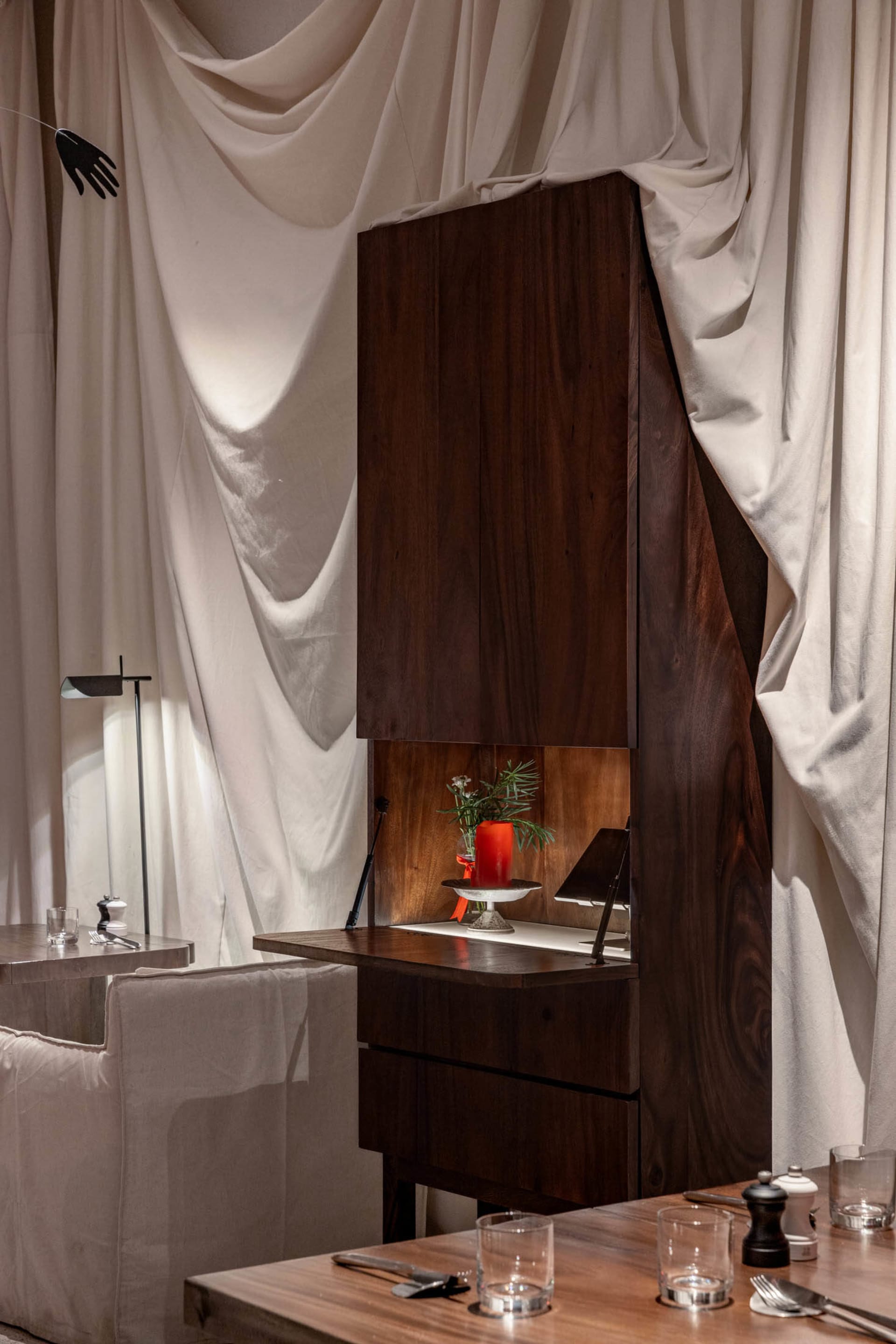 a modern kitchen with a wooden cabinet, sink, and two chairs, suggesting a cozy and functional living space