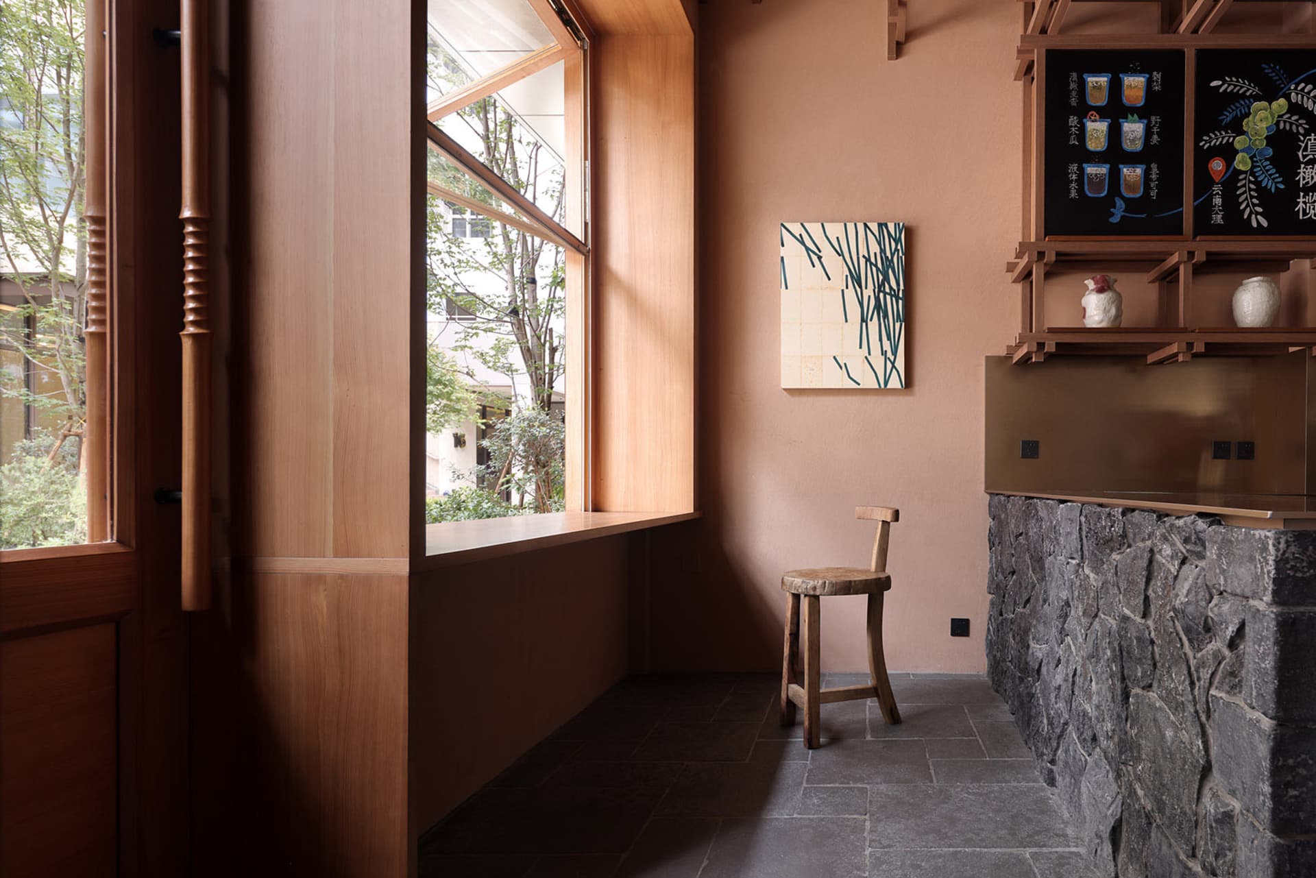 A warm and inviting living space with a brown-colored room, a dining table, two chairs, and large windows allowing natural light to enter