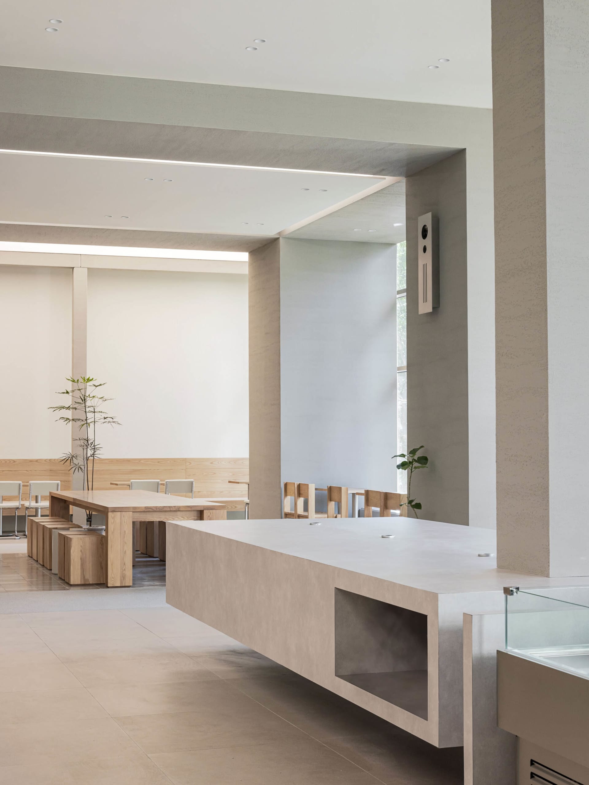 Empty room with a central countertop, chairs, and a dining table, exuding a calm and inviting atmosphere with a focus on functionality and comfort