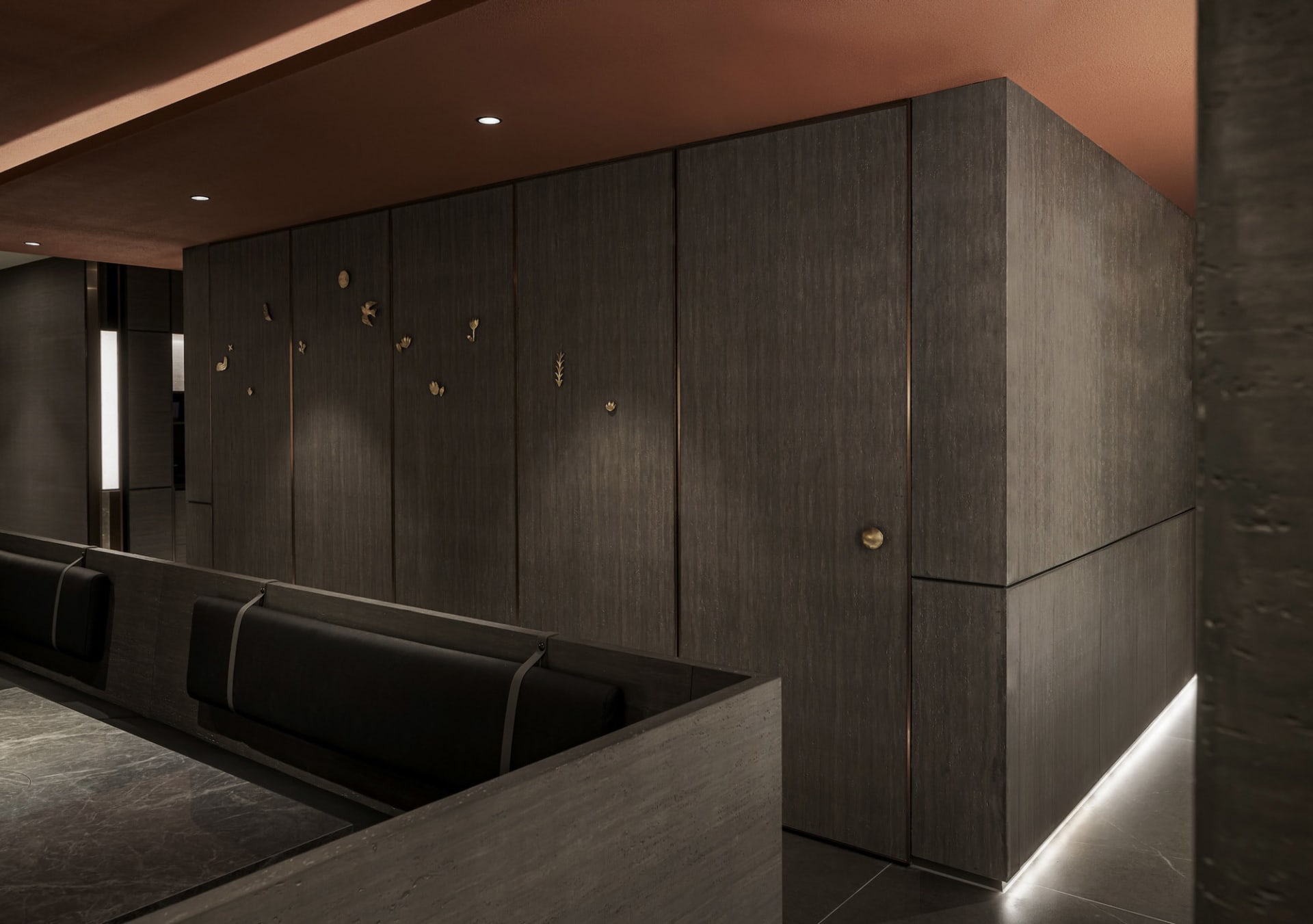 A warm and inviting room with wooden walls and floors, featuring two couches and three benches for ample seating