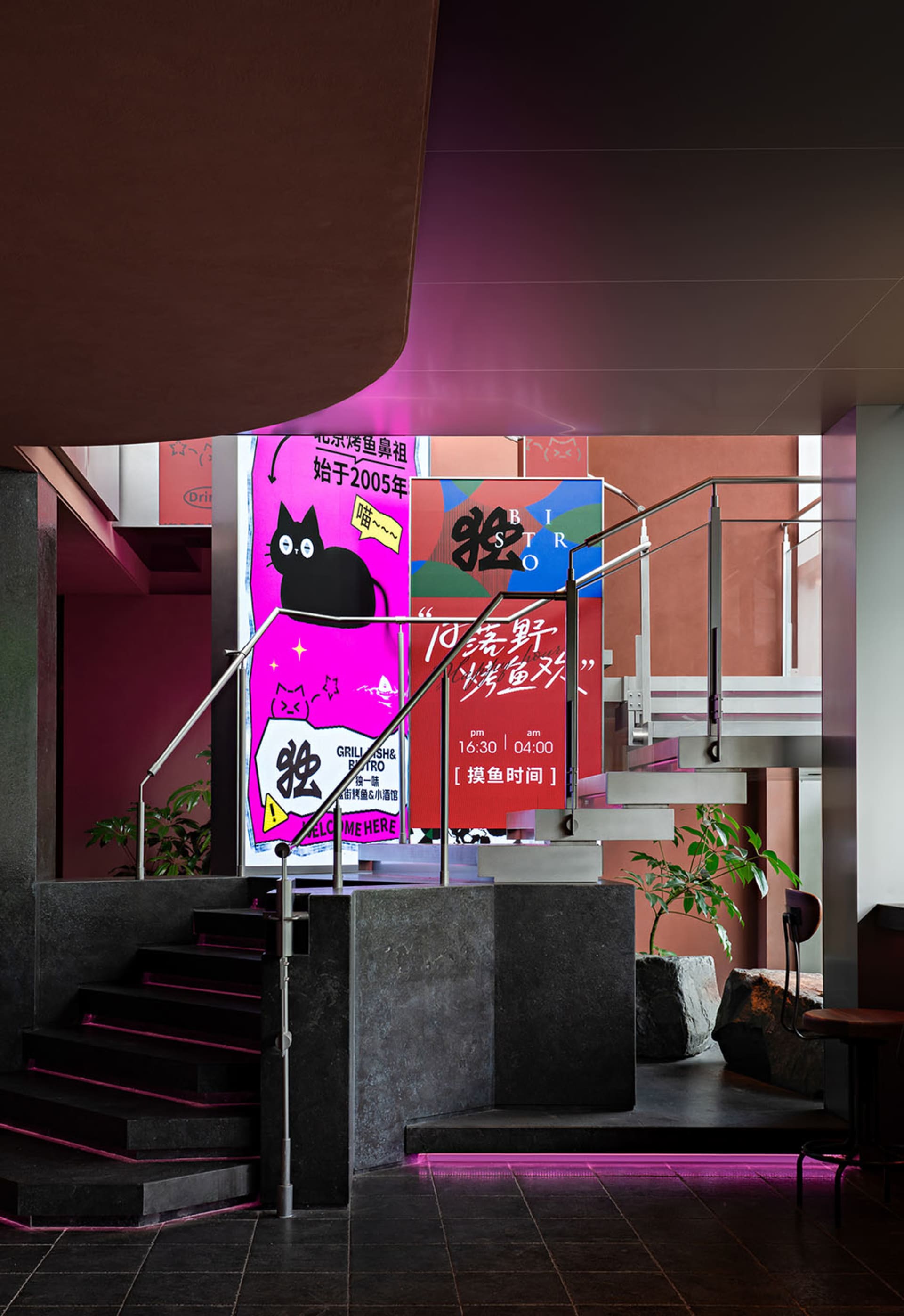 Modern office space with red walls, a staircase, and signs on display, featuring a functional design with a focus on practicality
