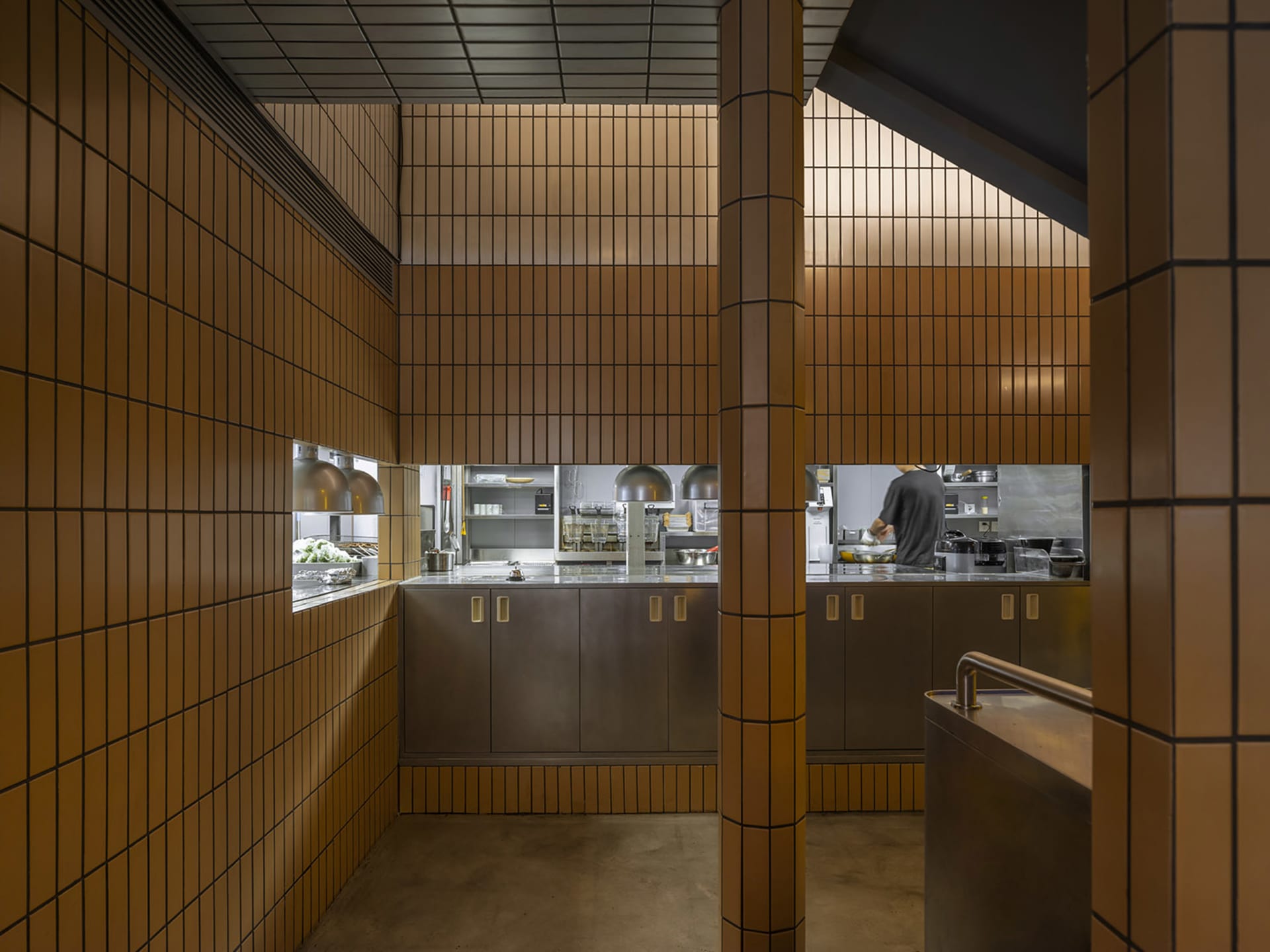 一間餐廳廚房，配有吧台、兩個水槽，以及各式廚具與食材