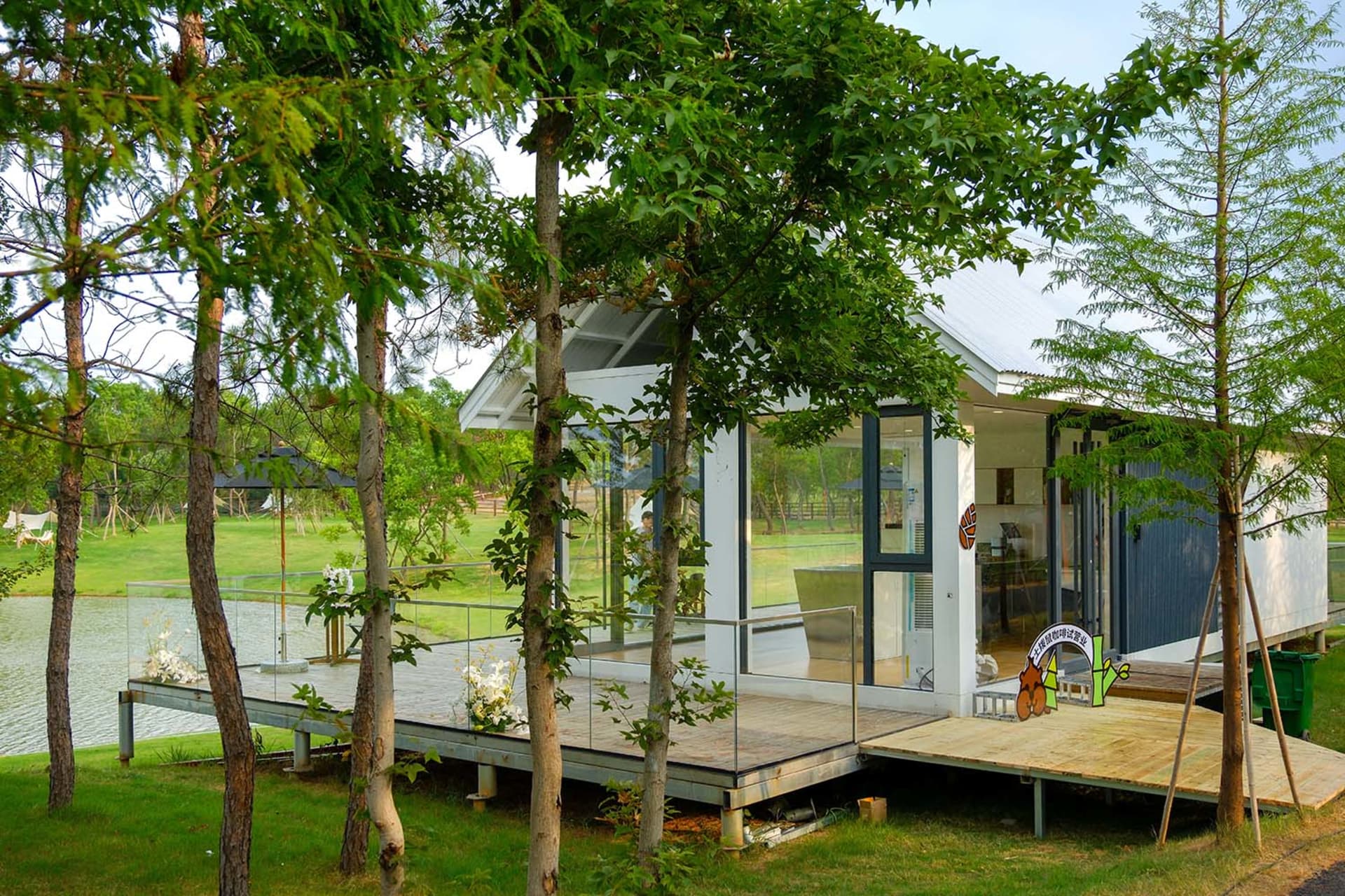Modern house with a wooden exterior, large windows, and a natural ambiance with trees outside