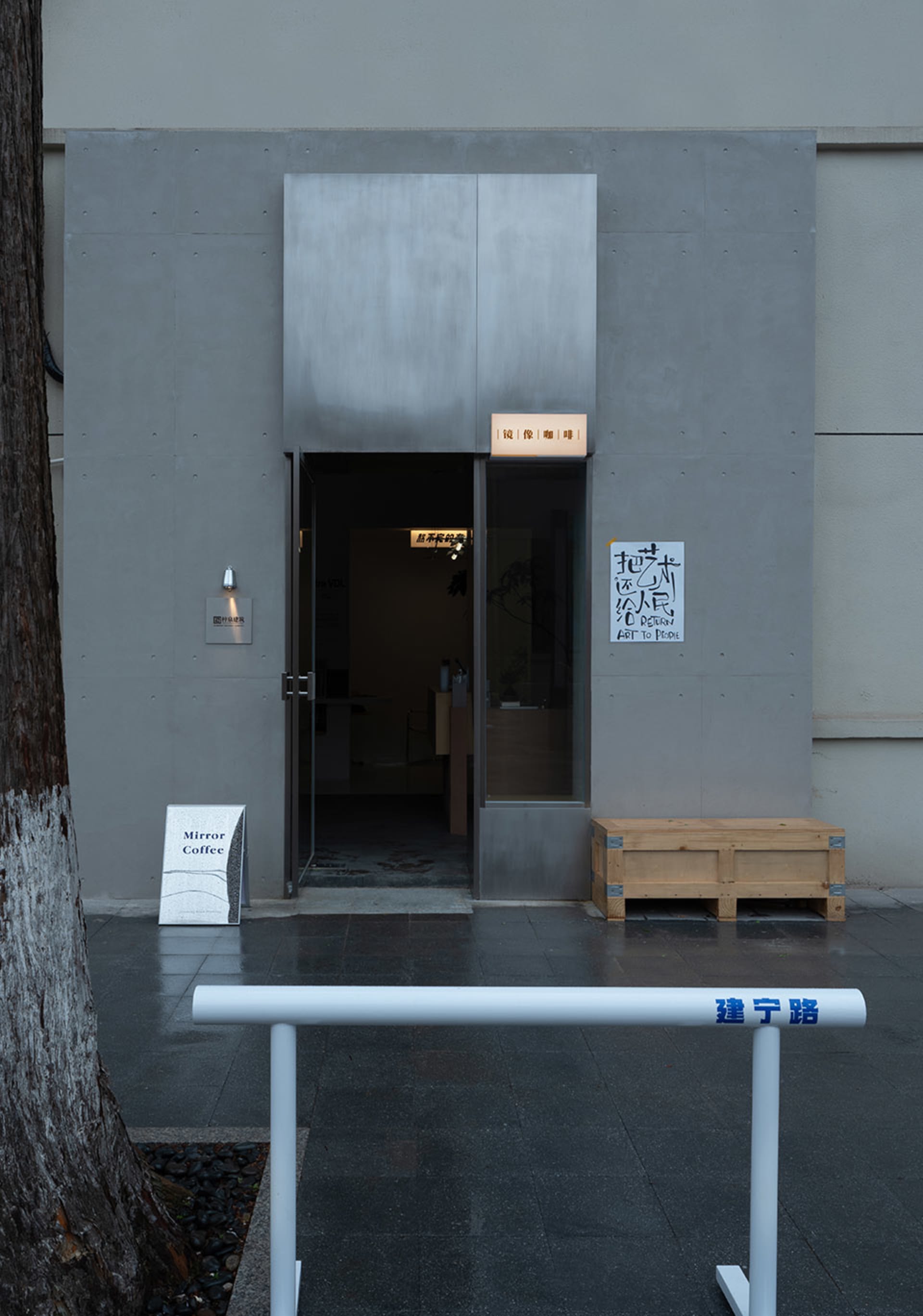 一間現代亞洲風咖啡店，擁有寬敞門口、椅子與餐桌，營造溫馨舒適的氛圍