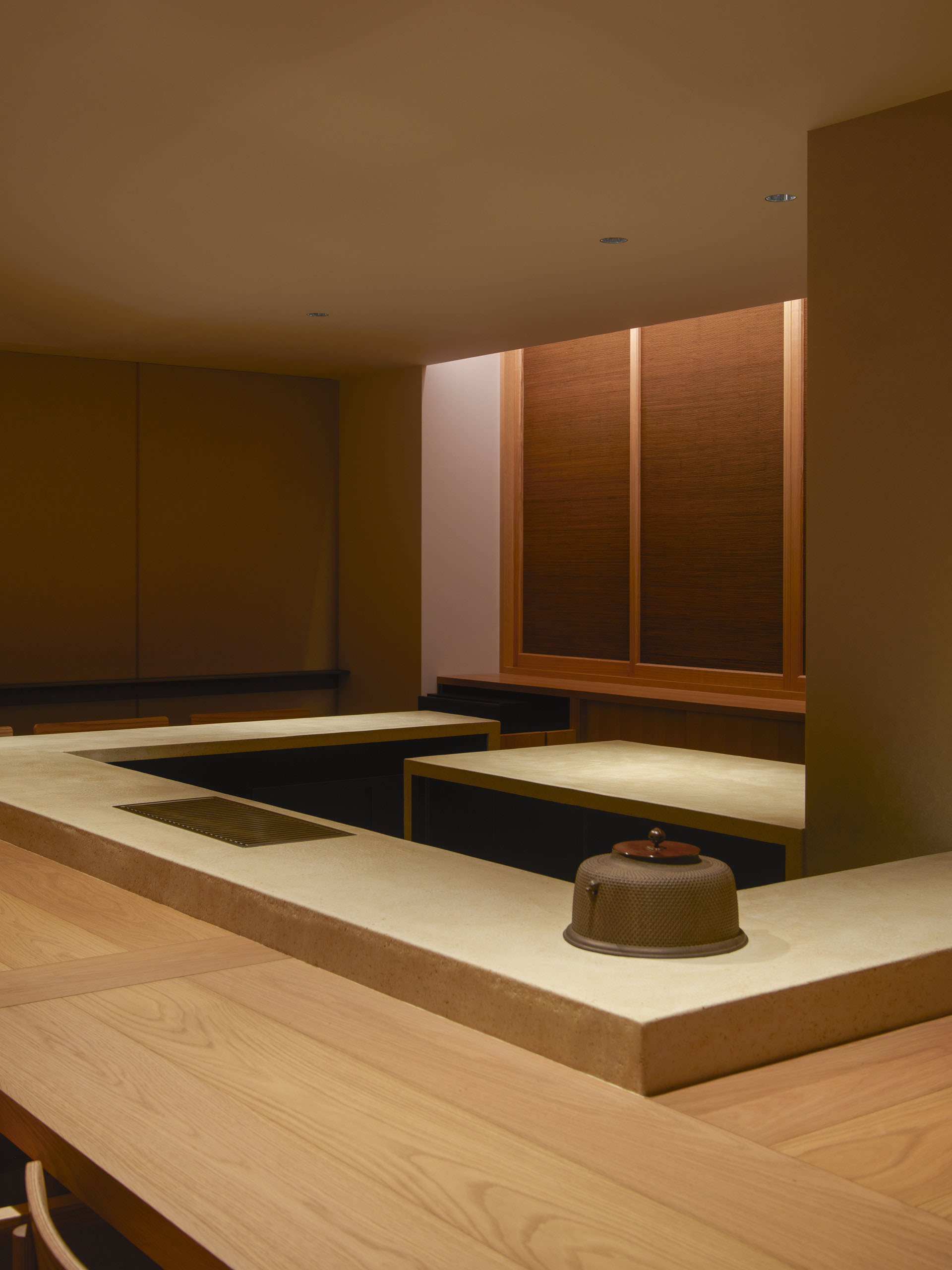 Warm and inviting Asian-style kitchen with wooden walls, stone countertops, and two sinks, set against a neutral background