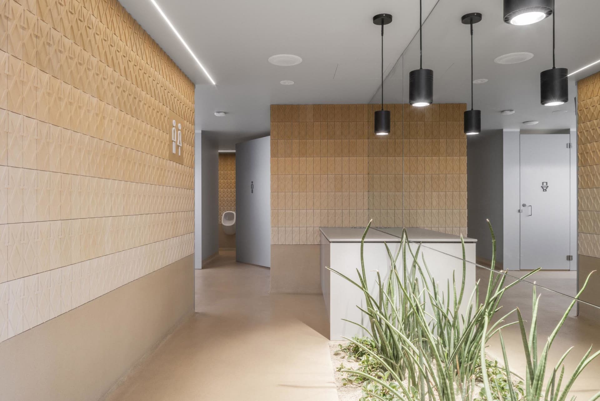 Modern bathroom with two sinks, a toilet, and a tiled wall and floor, suggesting a clean and modern appearance