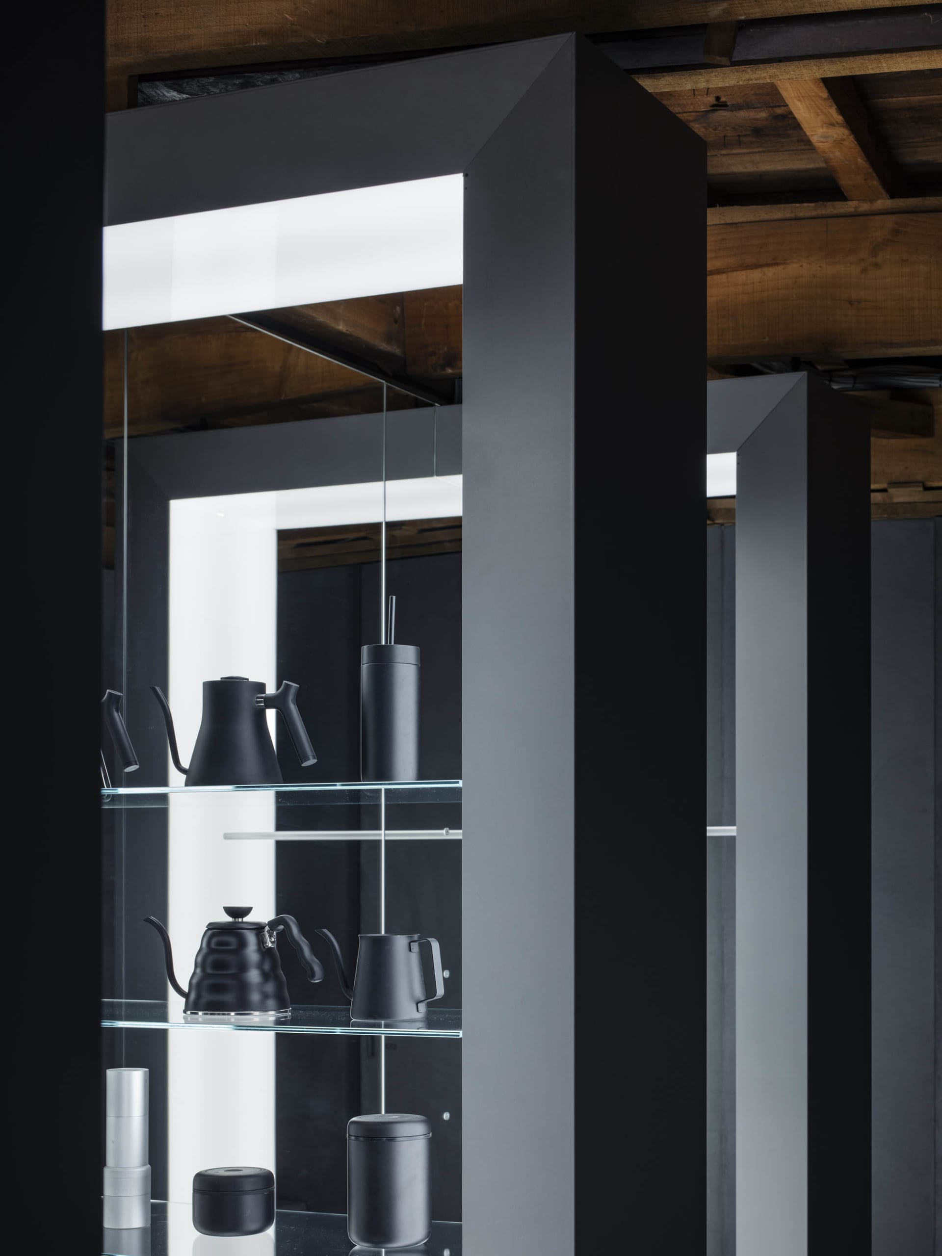 Elegant modern interior with black and white color scheme, glass shelf, and various vases in different sizes and shapes