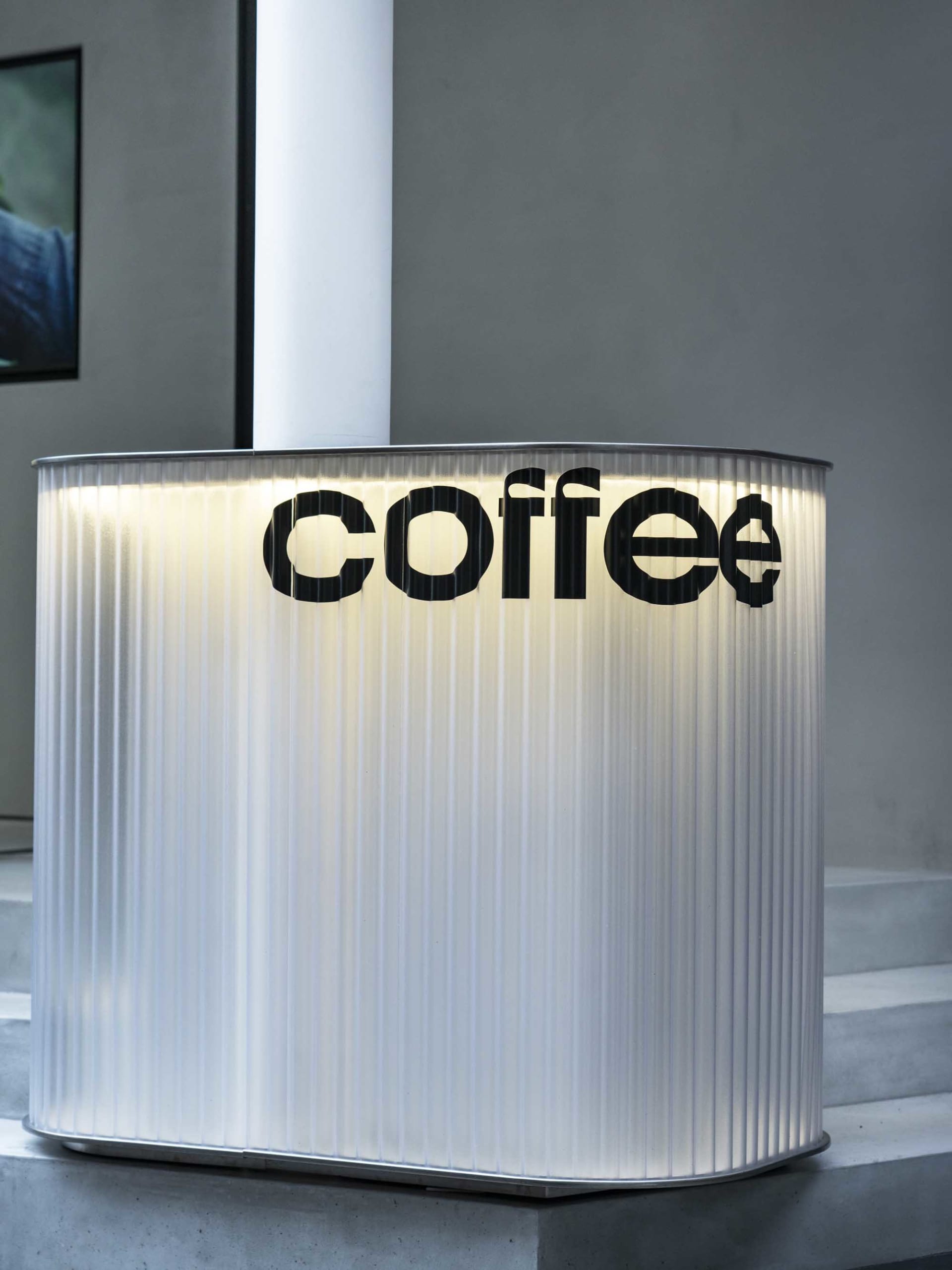A modern coffee shop counter with a sleek stainless steel surface, showcasing the coffee shop's logo in a contemporary and inviting environment