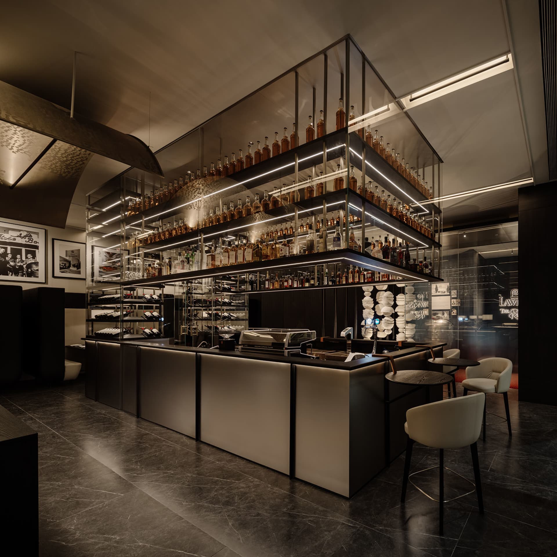 A sophisticated bar area with a long wooden counter and a display of liquor bottles, surrounded by comfortable seating and warm lighting