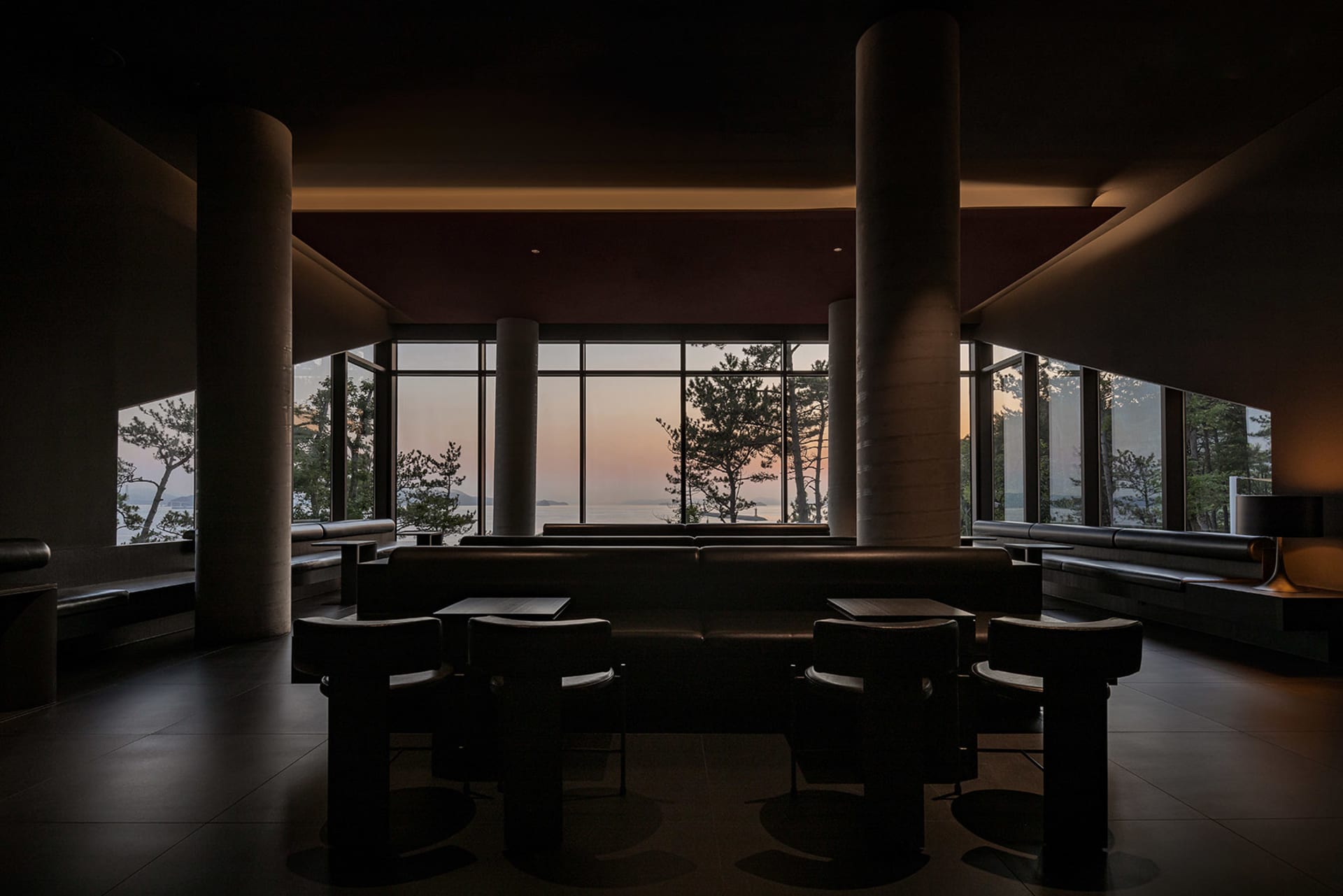 Modern restaurant interior with open seating area, clean lines, and minimalistic elements, featuring dining tables and chairs