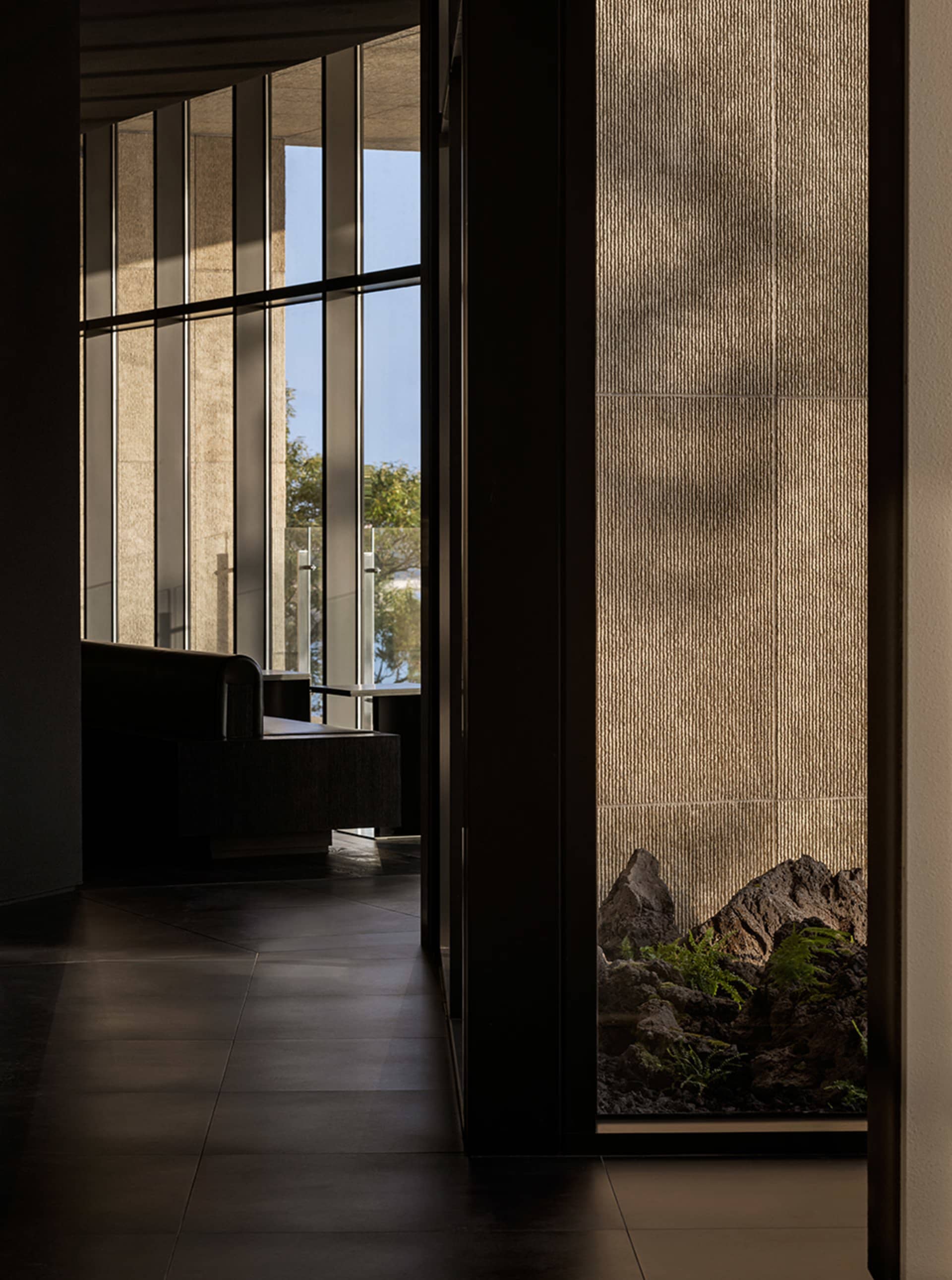 Bright and inviting living area with two couches, a chair, and a large window allowing sunlight to enter the space