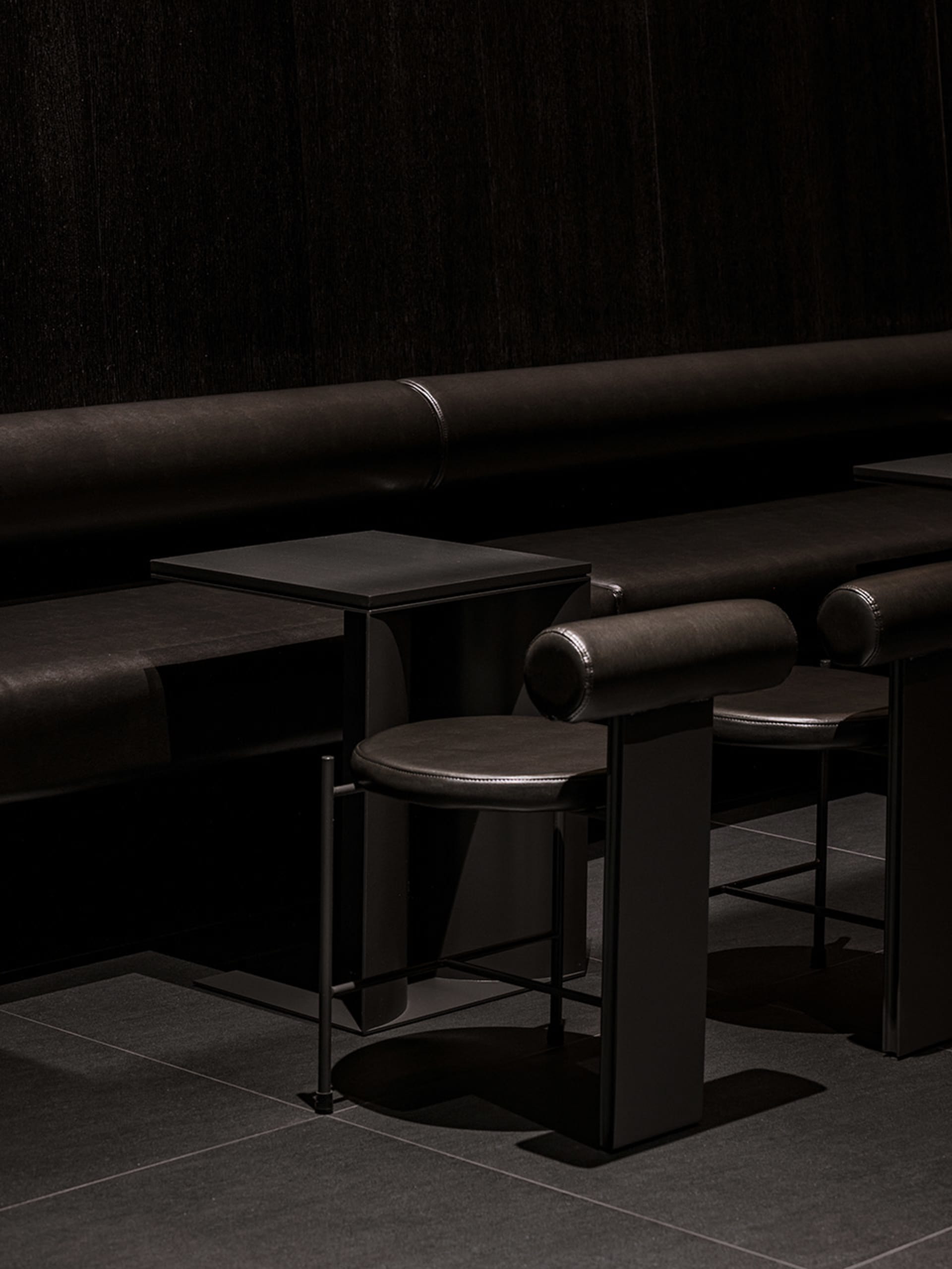 Cozy cafe interior with brown leather benches, wooden tables, and chairs, creating a warm and inviting atmosphere