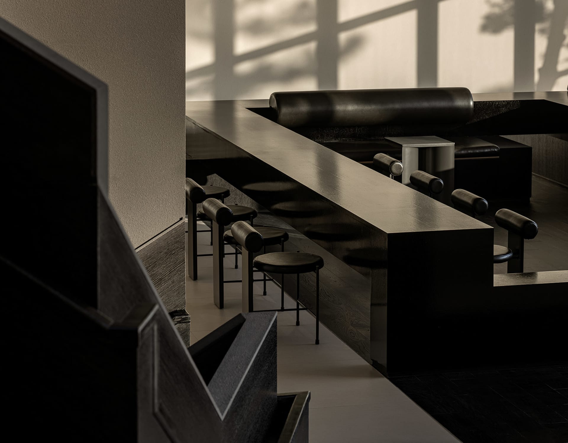 Empty modern restaurant with black tables and chairs arranged in rows, minimalist decoration, and a focus on functionality
