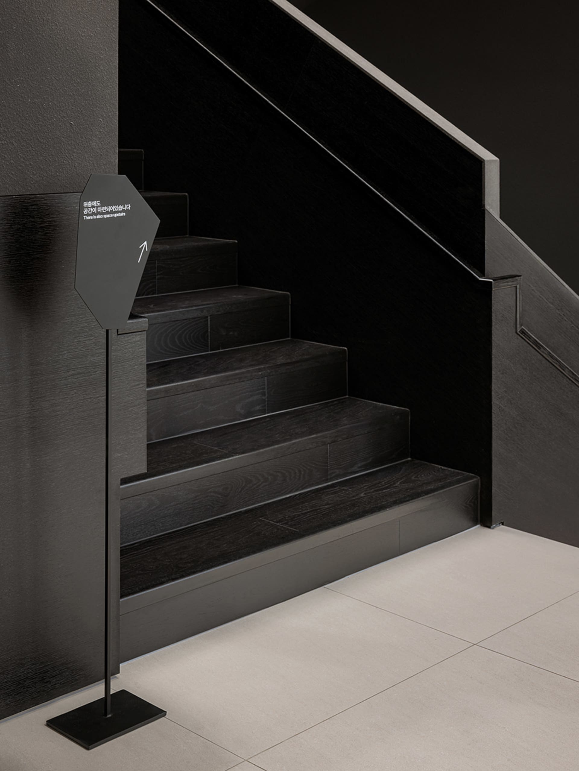 A well-lit stairwell with a wooden staircase, creating a sense of depth and dimension in a functional yet inviting environment
