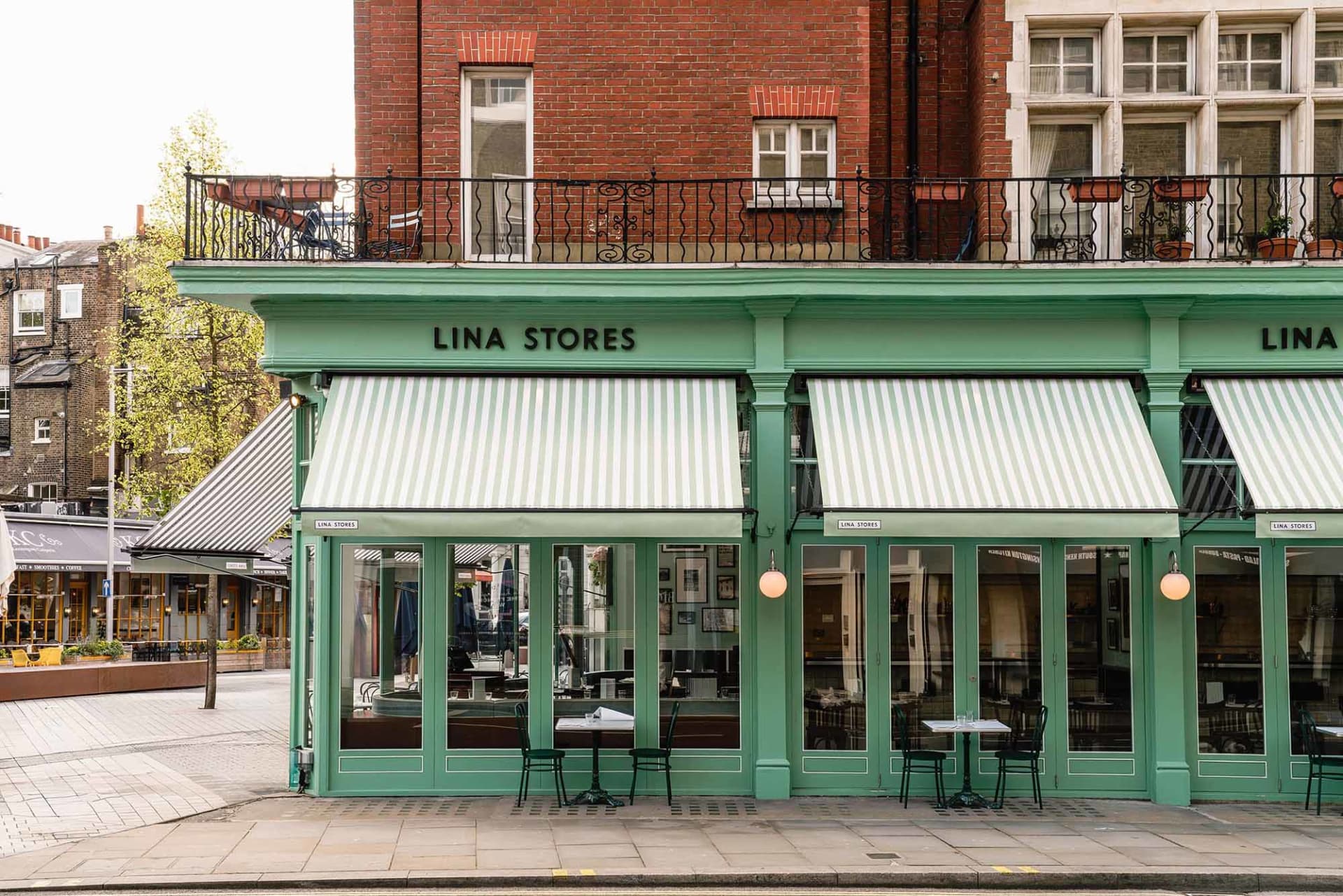 A casual storefront with outdoor seating area featuring chairs arranged around the exterior of the building, creating a welcoming atmosphere for customers